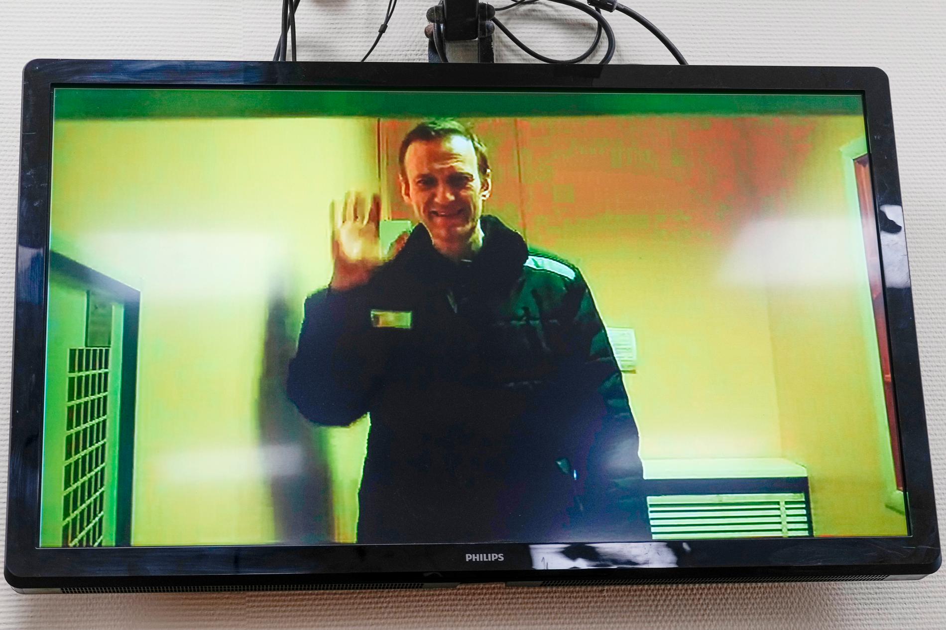 Den ryske oppositionspolitikern Aleksej Navalnyj på en tv-skärm där han deltar i en domstolsförhandling på distans. Arkivbild.