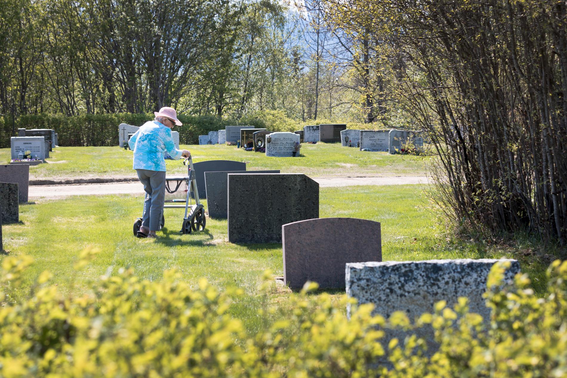 En äldre kvinna på en kyrkogård. Arkivbild.
