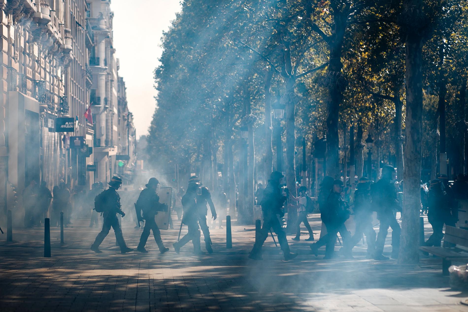 Kravallpolis på Champs-Élysées efter att tårgas använts mot demonstranter i Paris.