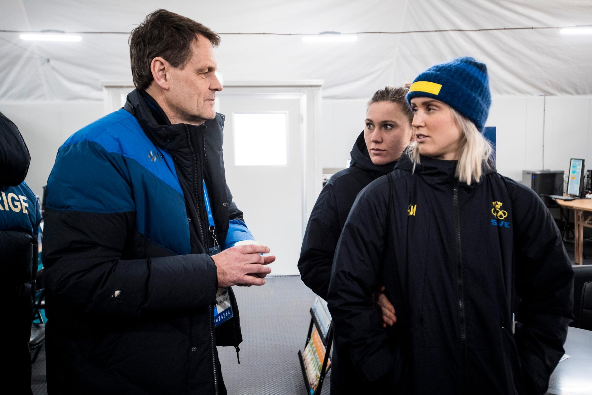 Peter Reinebo i OS-byn, här med alpinåkarna Estelle Alphand och Emelie Vikström.