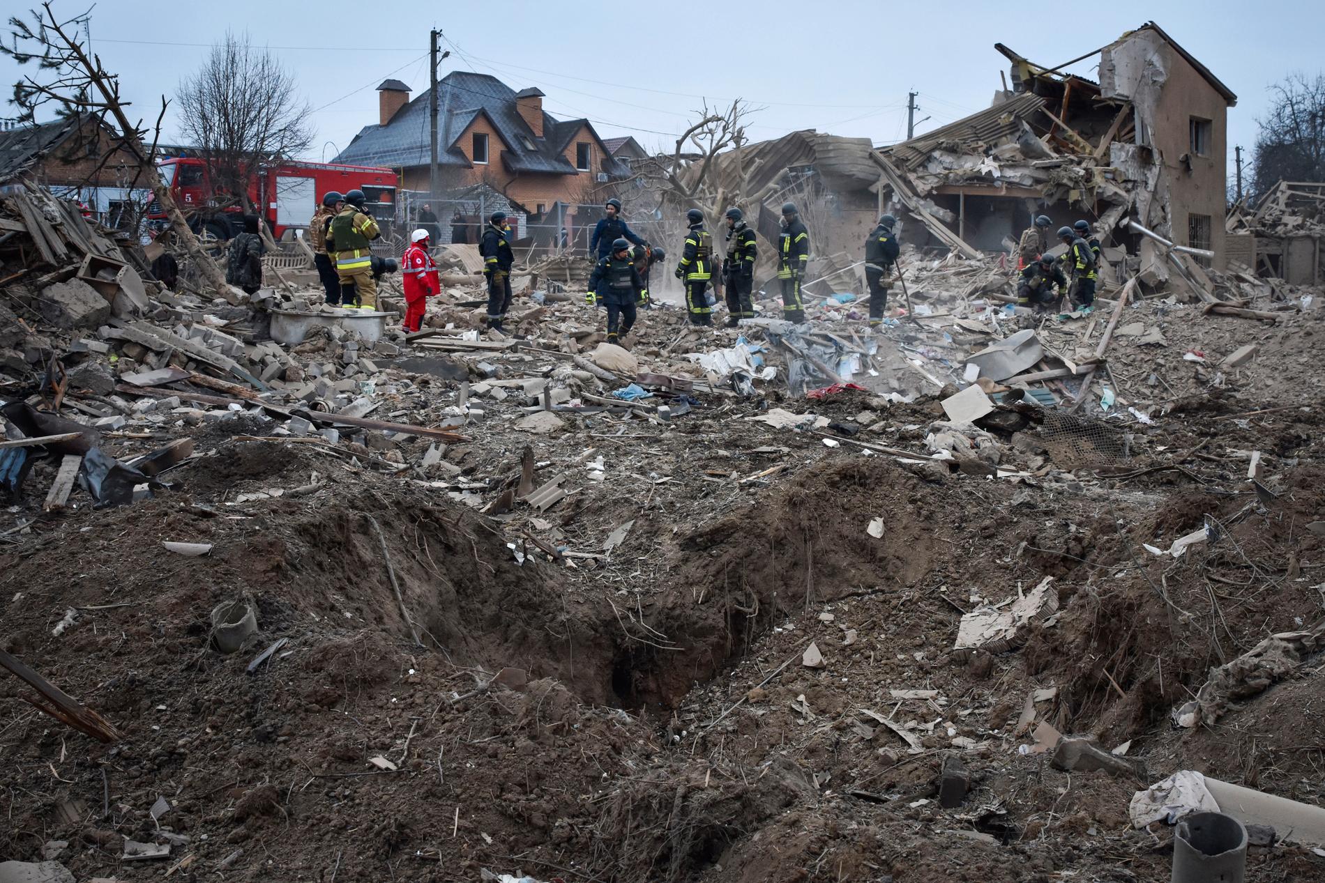Ukrainska räddningsarbetare i arbete efter ett stort ryskt anfall mot Zaporizjzja under natten till fredag.