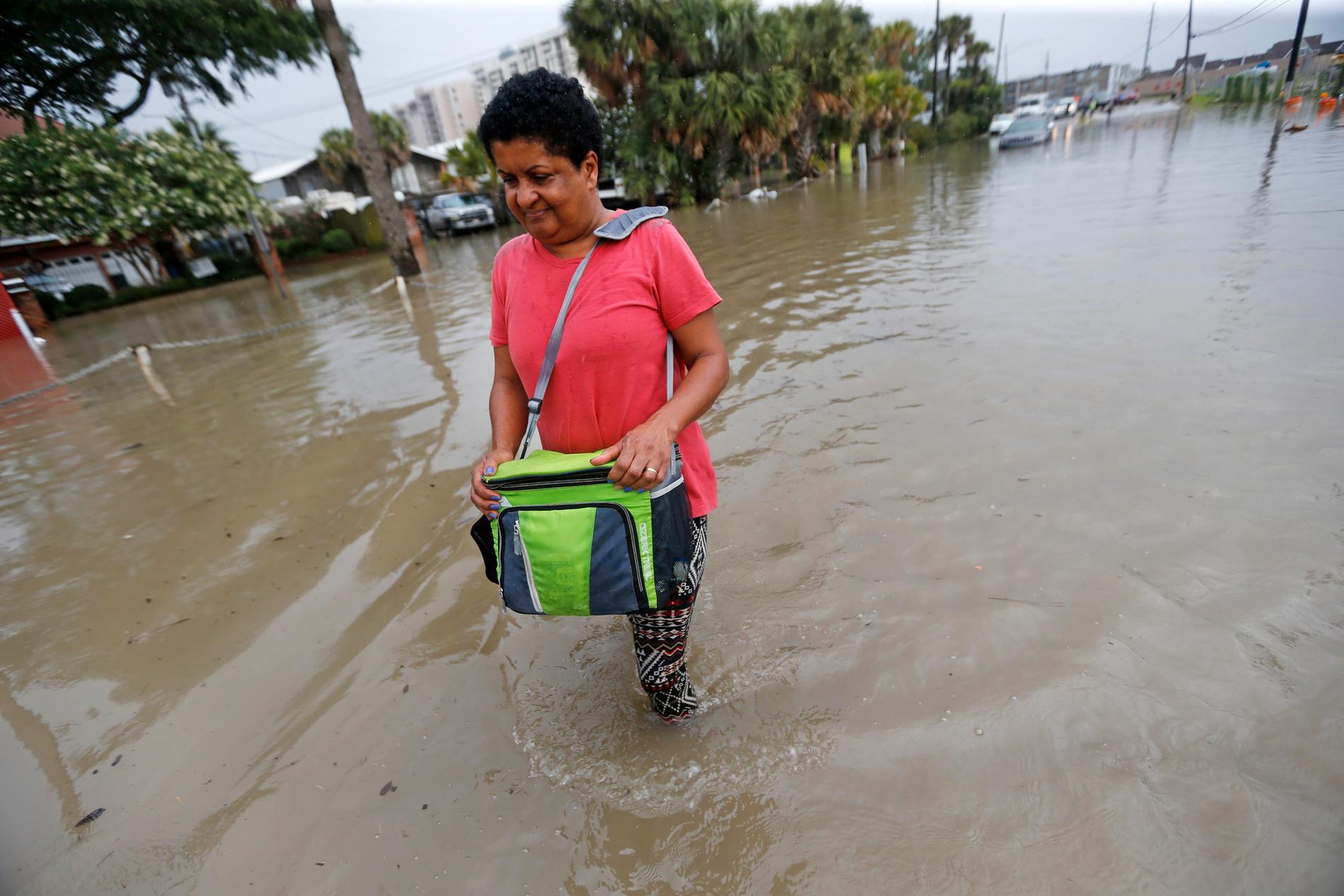 Esther Martens går på en översvämmad gata för att komma åt sin bil i västra delen av New Orleans på onsdagen.