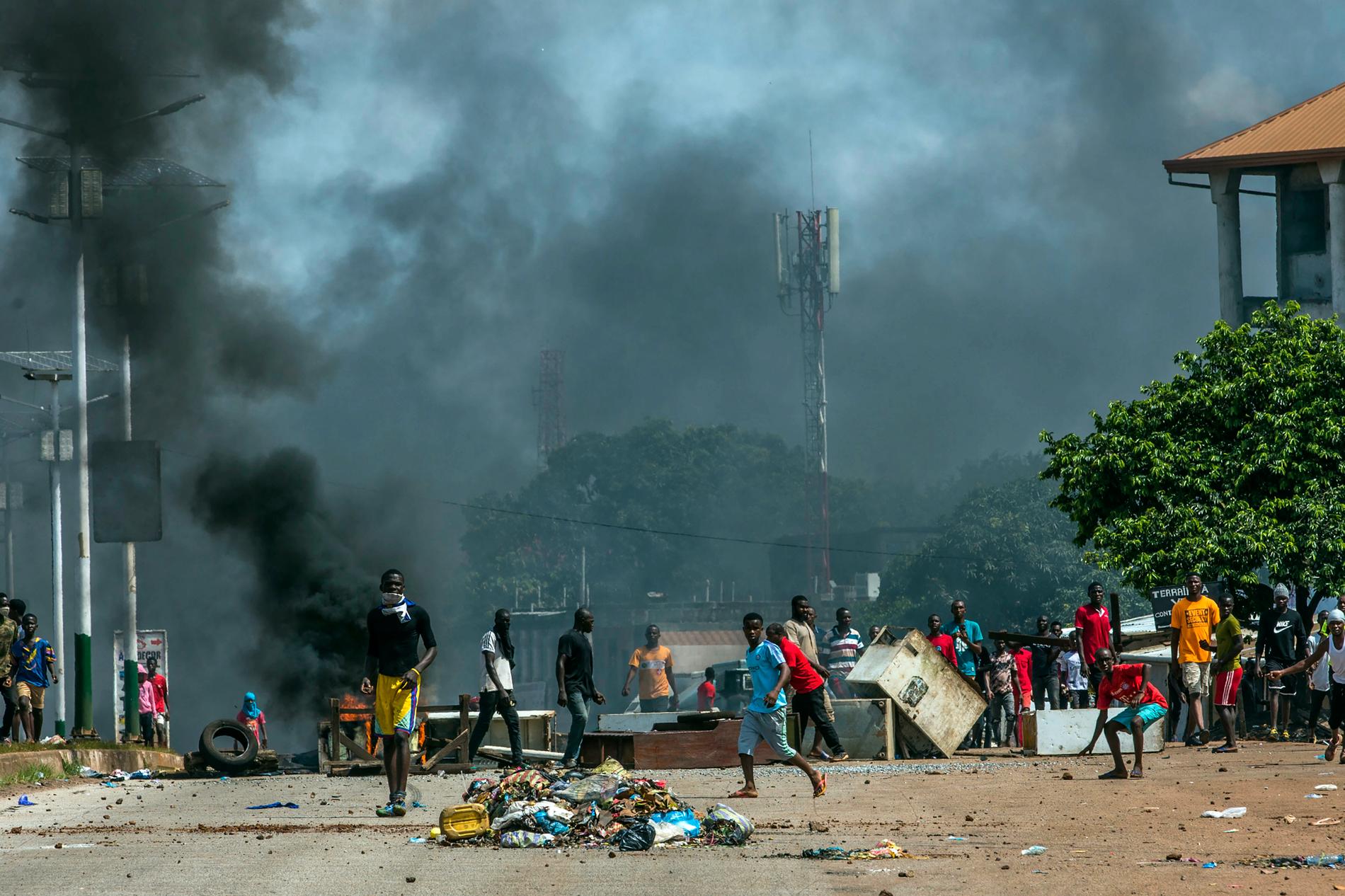 Anhängare till oppositionsledaren Cellou Dalein Diallo kastar sten mot polisen i Guineas huvudstad Conakry.