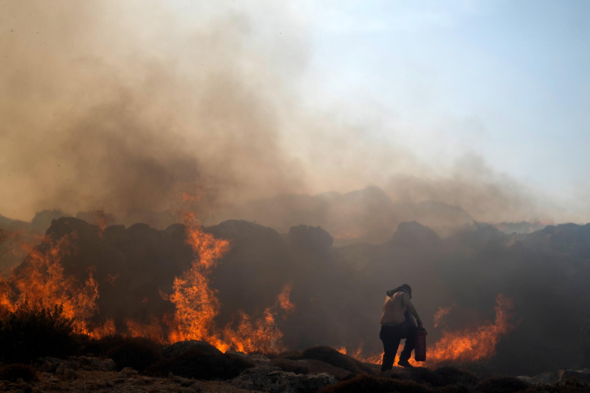 Brandbekämpning utanför Lindos på den grekiska ön Rhodos i juli förra året.