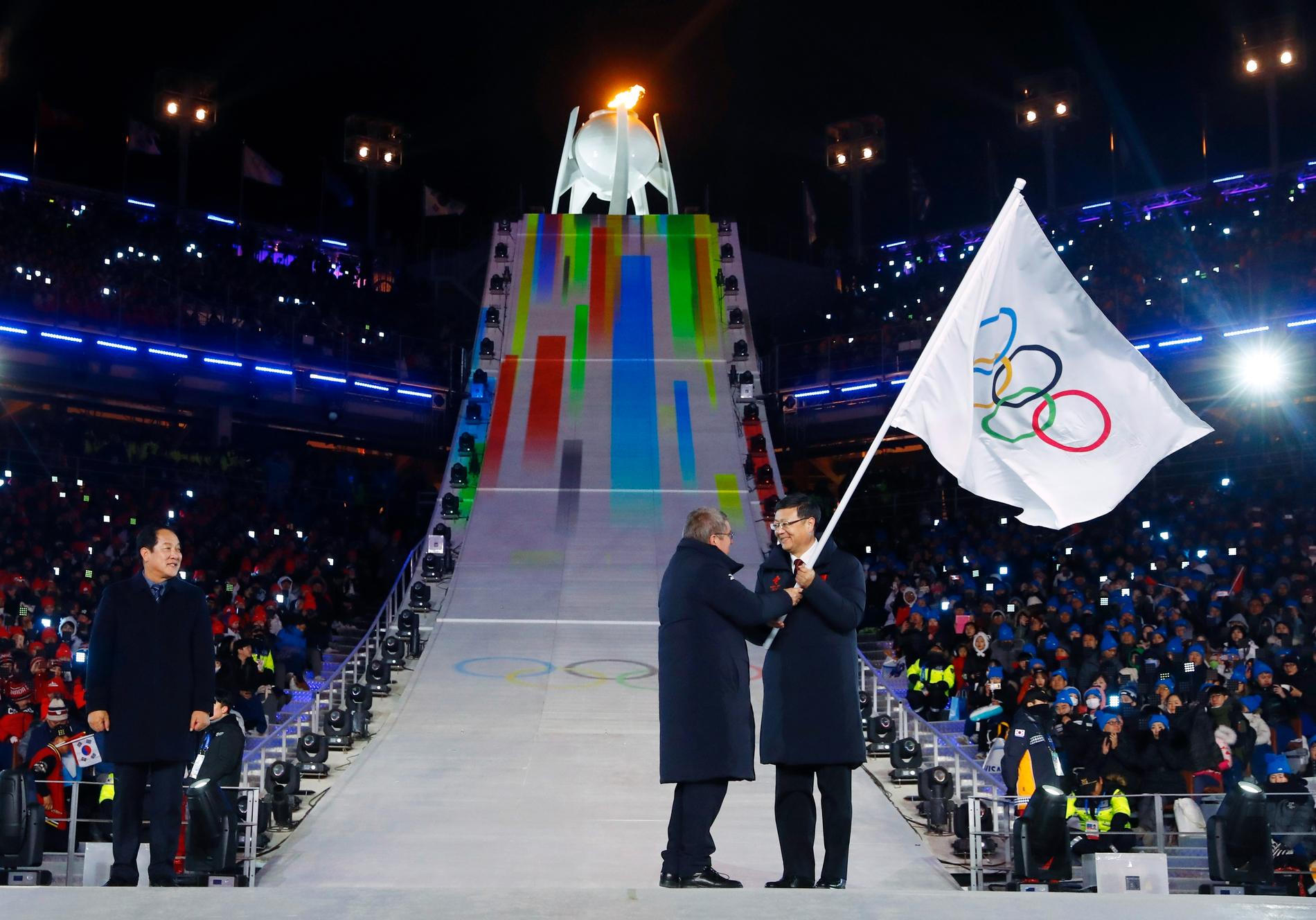 Pekings borgmästare får motta OS-flaggan från IOK:s president under avslutningsceremonin i OS i pyeongchang 2018 