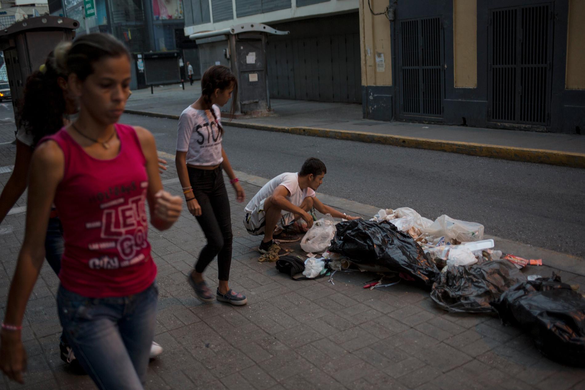 Caracasbon Kevin Gonzalez letar efter mat i skräpet längs huvudstadens gator. Den djupa ekonomiska krisen i Venezuela har tvingat miljoner människor på flykt och de som är kvar i landet får kämpa för att få tag på mat, vatten, medicin och andra förnödenheter. Bilden är från den 16 juli.