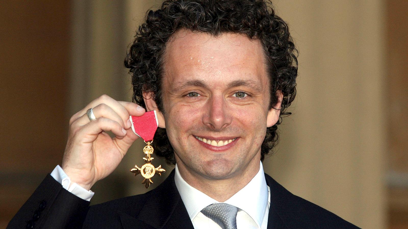 Michael Sheen med medaljen han mottog av drottning Elizabeth II 2009 - och lämnade tillbaka.