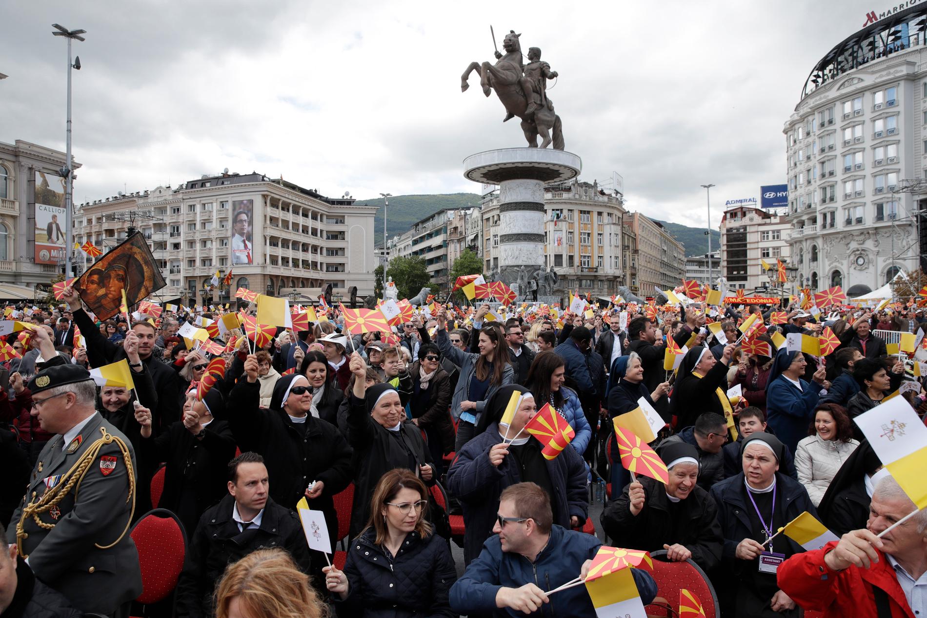 Människor välkomnar påve Franciskus när han anländer för att delta vid en mässa i Skopje.