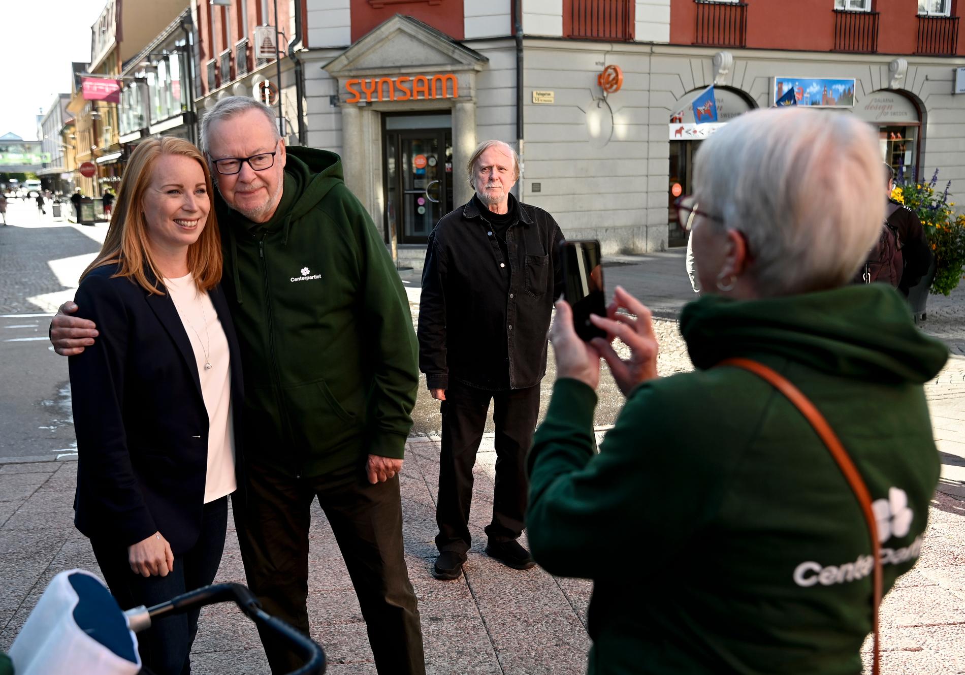 Annie Lööf tar selfies med lokala centerpartister. Örjan Hamrin tittar på i bakgrunden. 