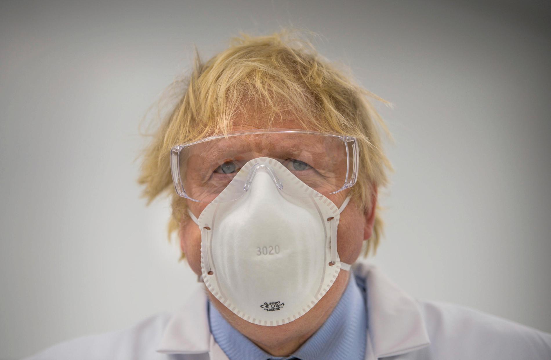 Storbritannien var bland de värst drabbade under pandemins första fas. Nu sköljer en fjärde våg av covid-19 över landet – vilket har väckt oro inför det stora klimatmötet i Glasgow. På bilden syns premiärminister Boris Johnson med munskydd i samband med ett besök på ett laboratorium tidigare i år.