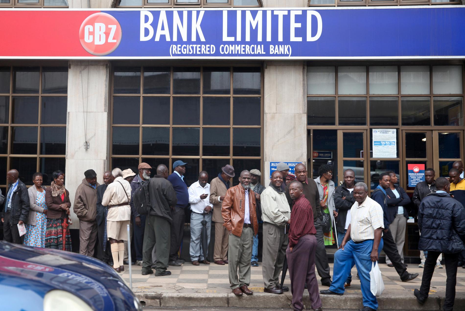 Människor köar för att ta ut pengar i huvudstaden Harare.