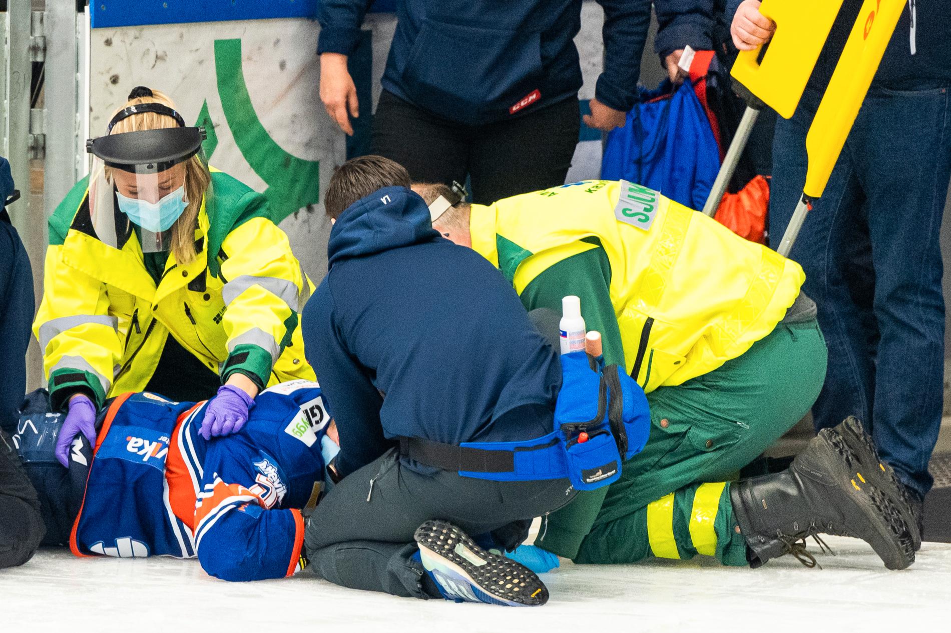 Juuso Vainio får läkarhjälp efter en olycklig smäll mot sargen. 