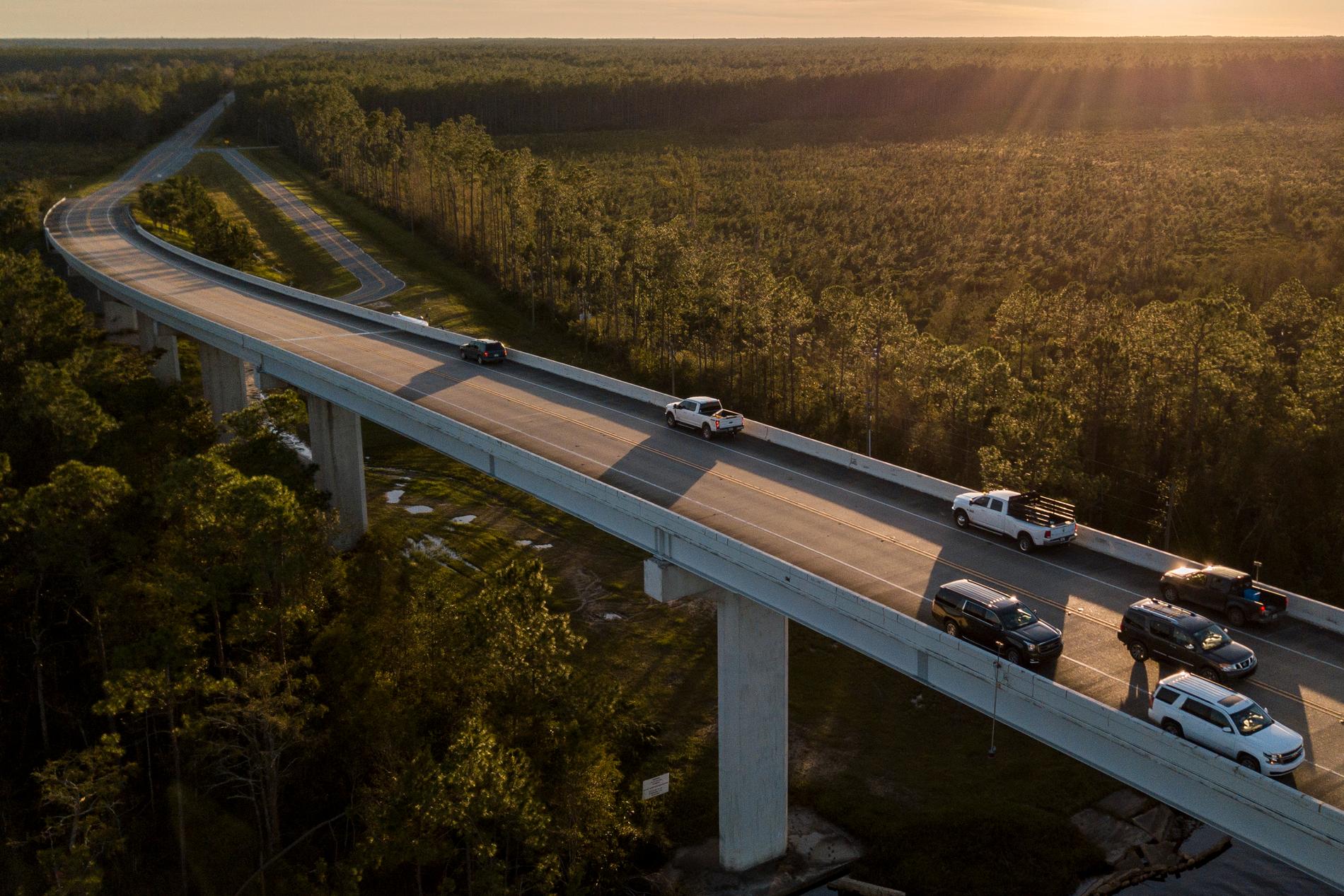 Bilister som har parkerat på en vägbro på Highway 71 nära Port Saint Joe i Florida. De ställer sig där i hopp om mobiltäckning, eftersom stora delar av kommunikationsnäten slagits ut av "Michael".