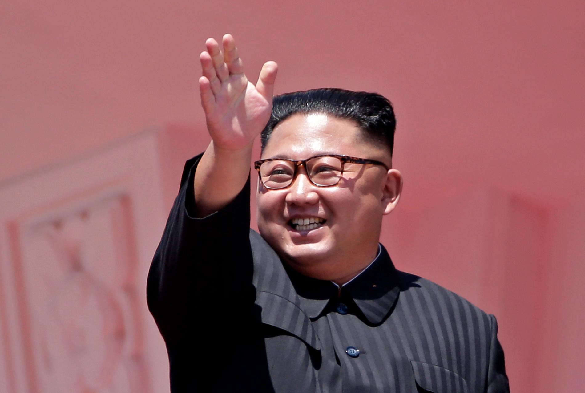 Nordkoreas diktator Kim Jong-Un vinkar vid söndagens militärparad där landets 70-årsdag firades.