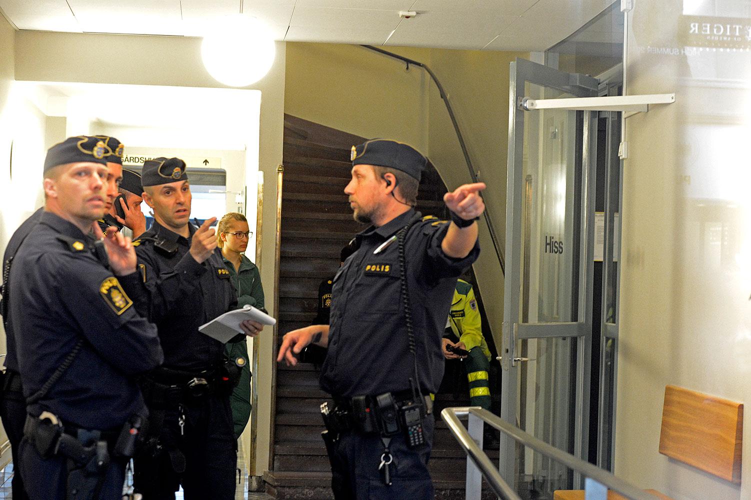 Polis och ambulanspersonal inne i fastigheten på Kungsgatan där René Akofely sköts ihjäl i maj.