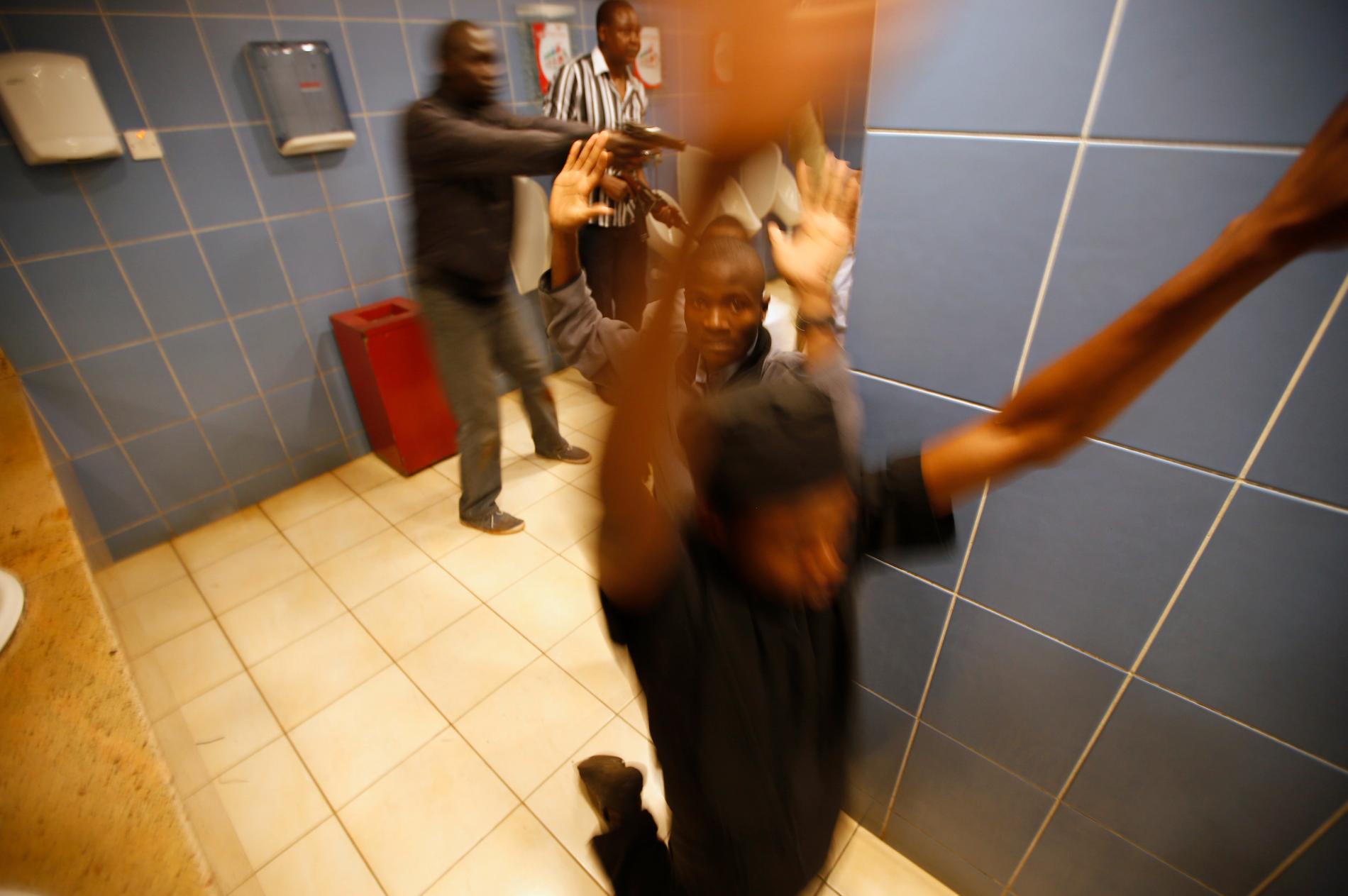 Beväpnad polis visiterar kunder som tagit skydd inne i gallerians toalett.