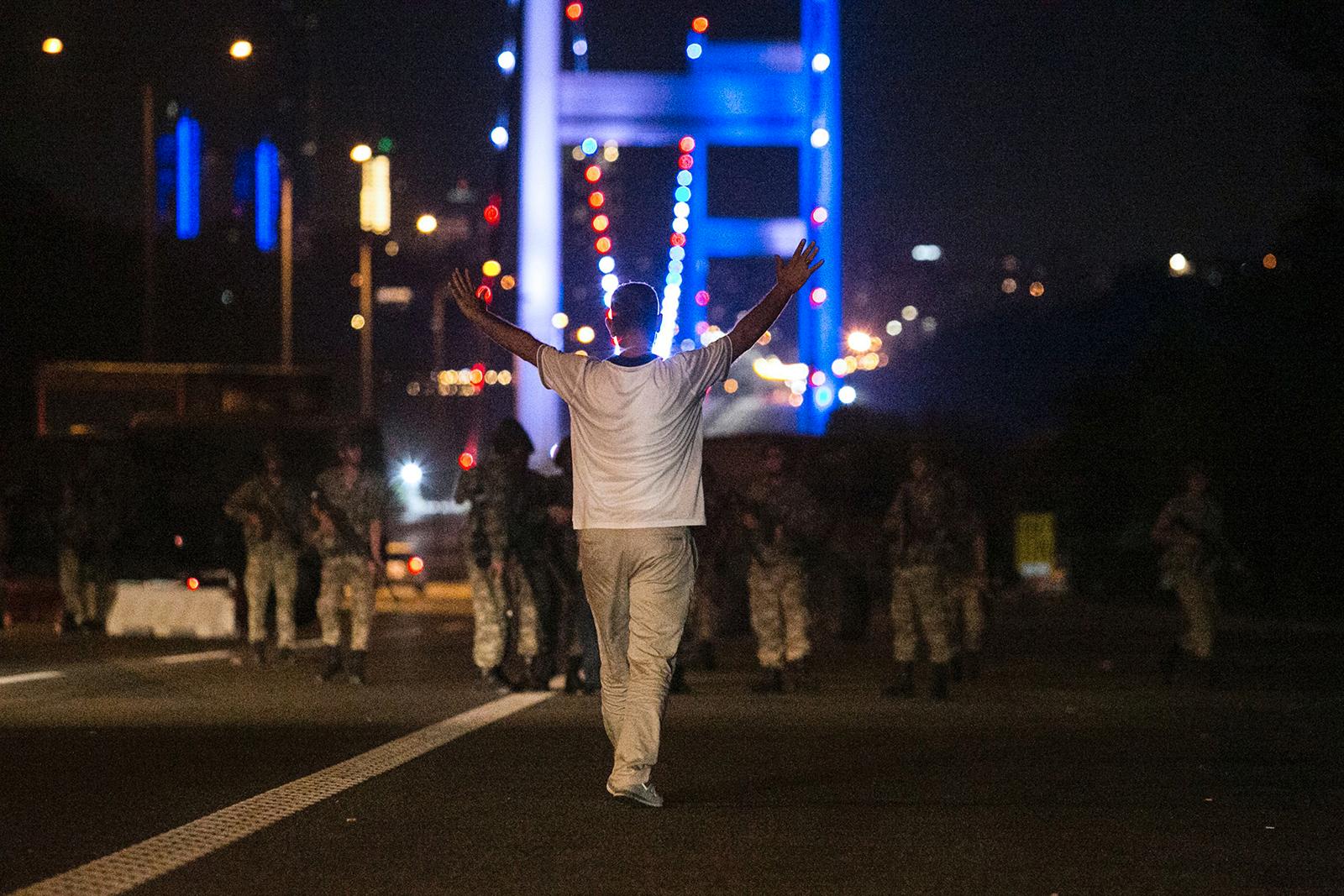 En man går med utsträckta armar mot militären som blockerat Bosphorusbron i Istanbul.