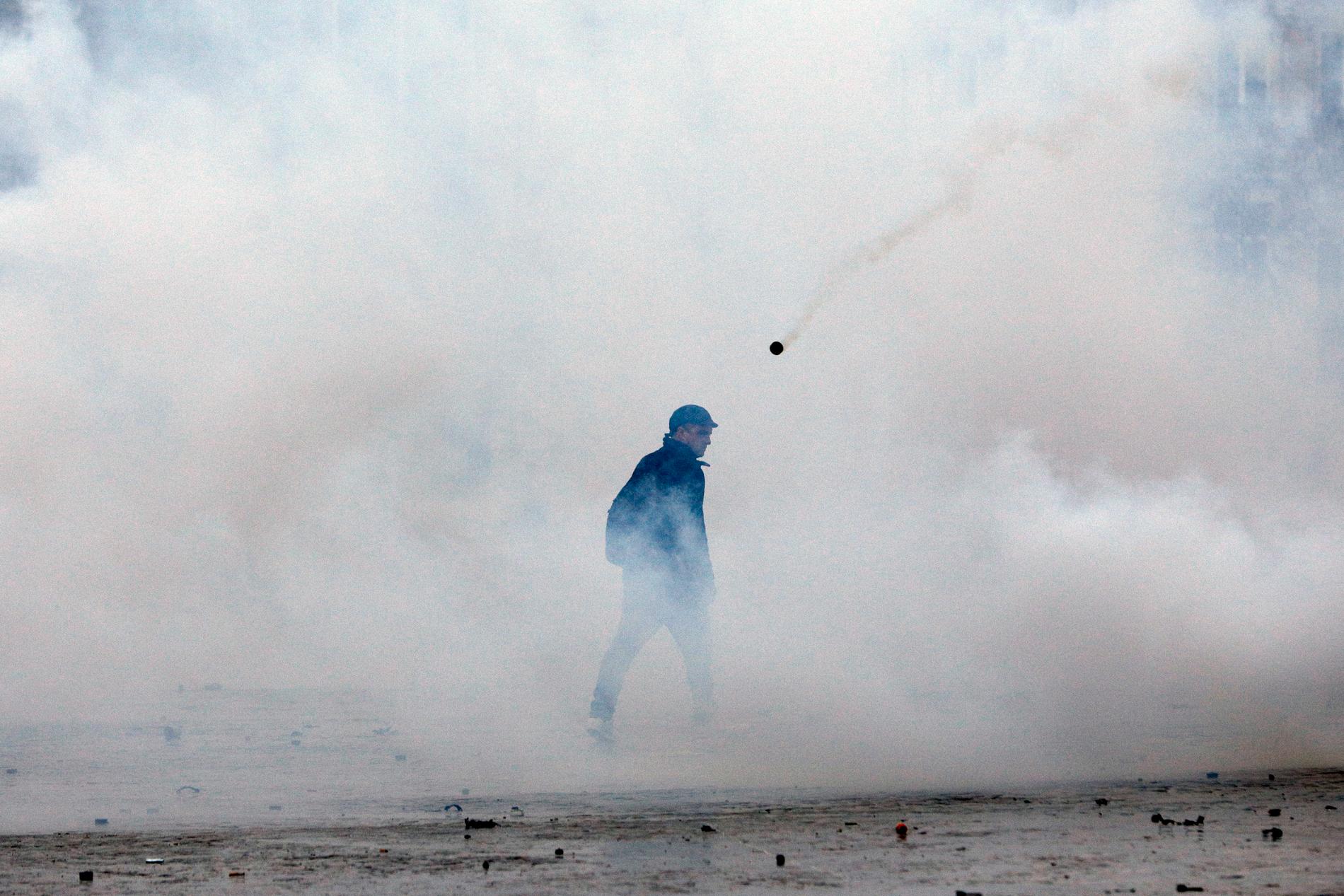 En demonstrant omgiven av tårgas i centrala Paris den gångna helgen. De senaste veckornas protester i Frankrike har utlösts av bland annat missnöje med stigande priser på fossila bränslen.