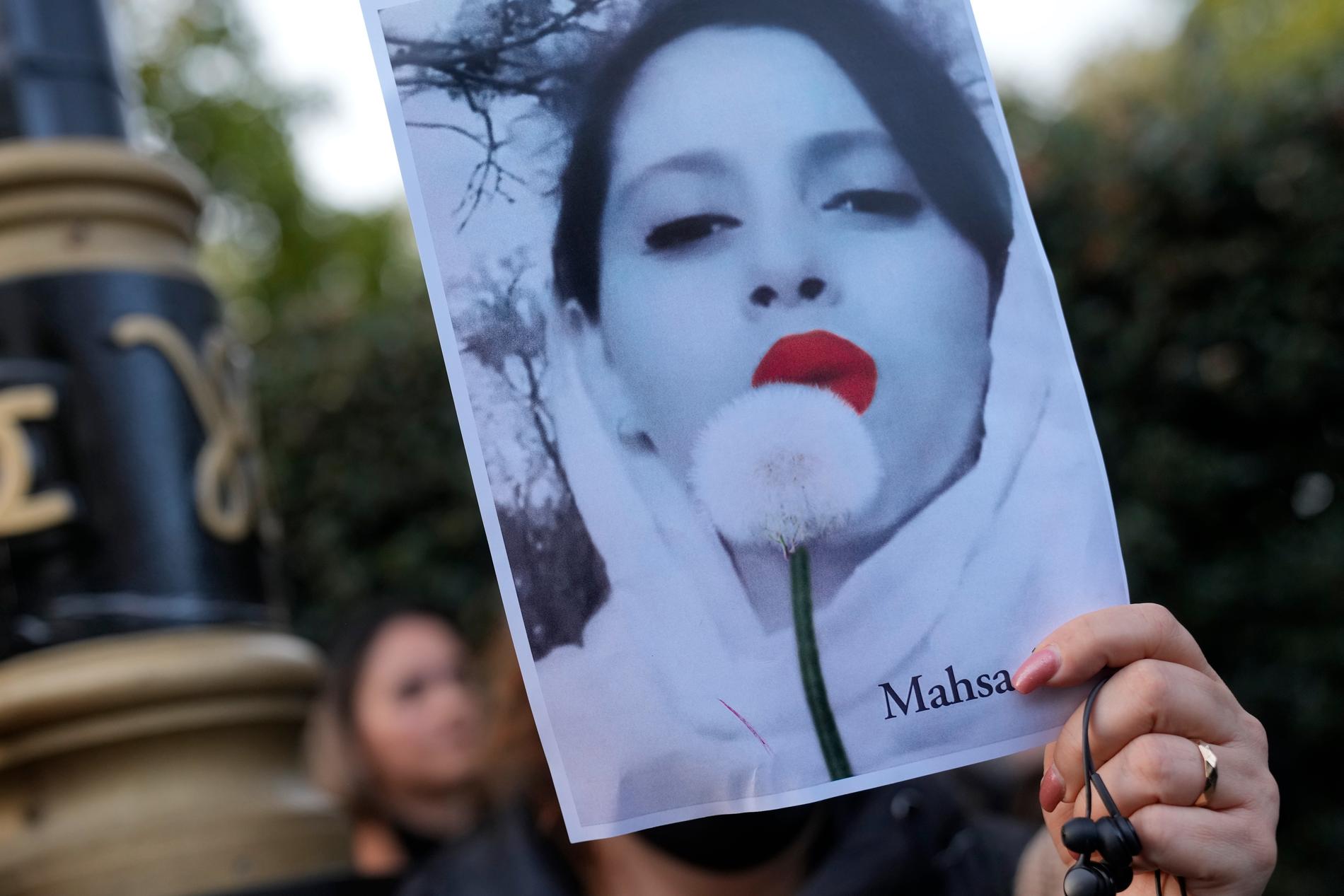 Demonstranter håller plakat utanför Irans ambassad i London, söndagen den 25 september 2022.