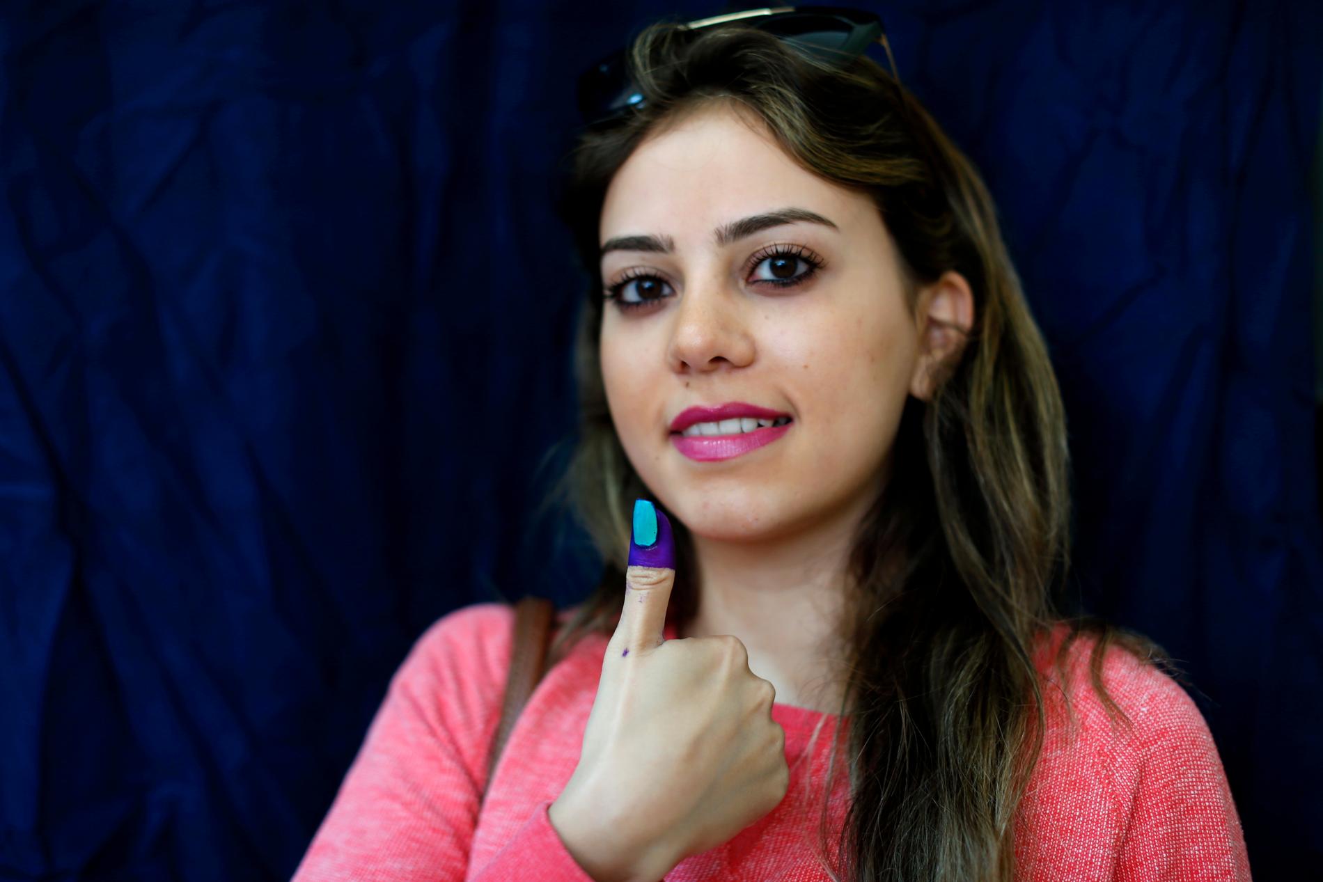 En libanesisk kvinna visar upp tummen med bläck som visar att hon röstat.