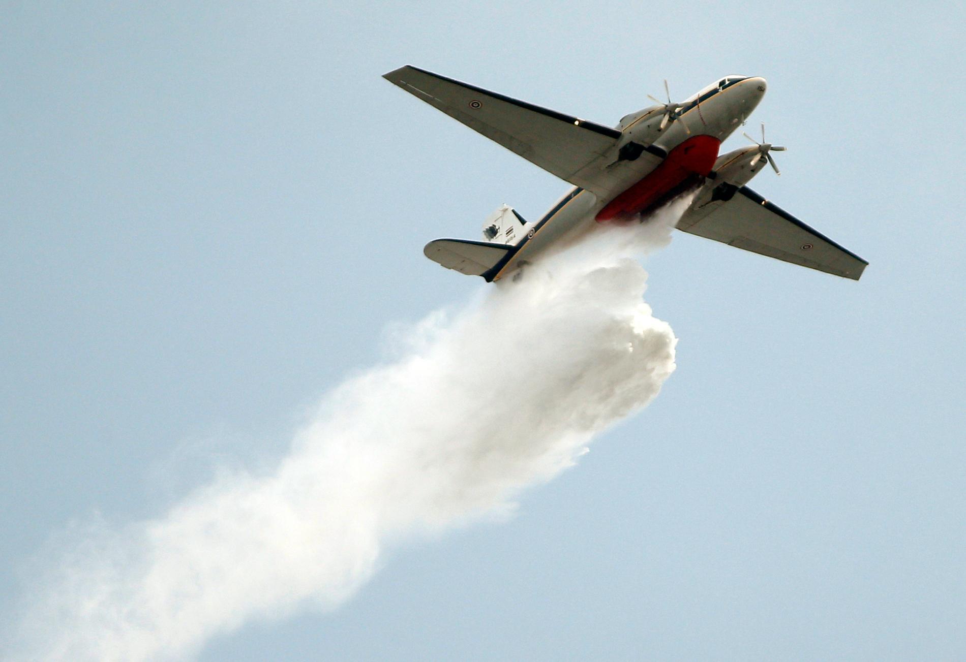 Ett plan från Thailands flygvapen sprayar vatten över Bangkok för att rensa luften.