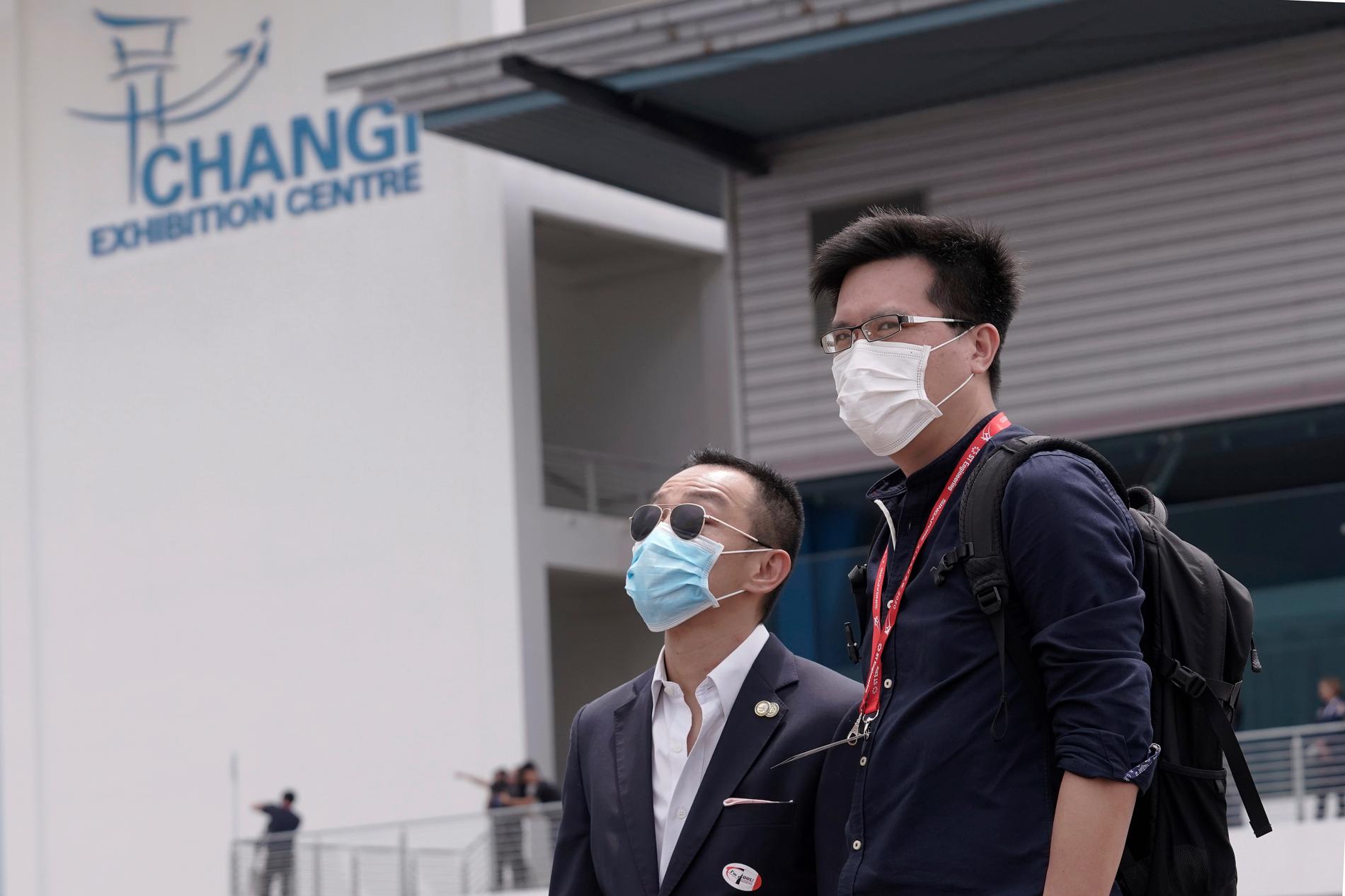 Besökare på Singapore Airshow har på sig munskydd mot viruset i februari 2020.