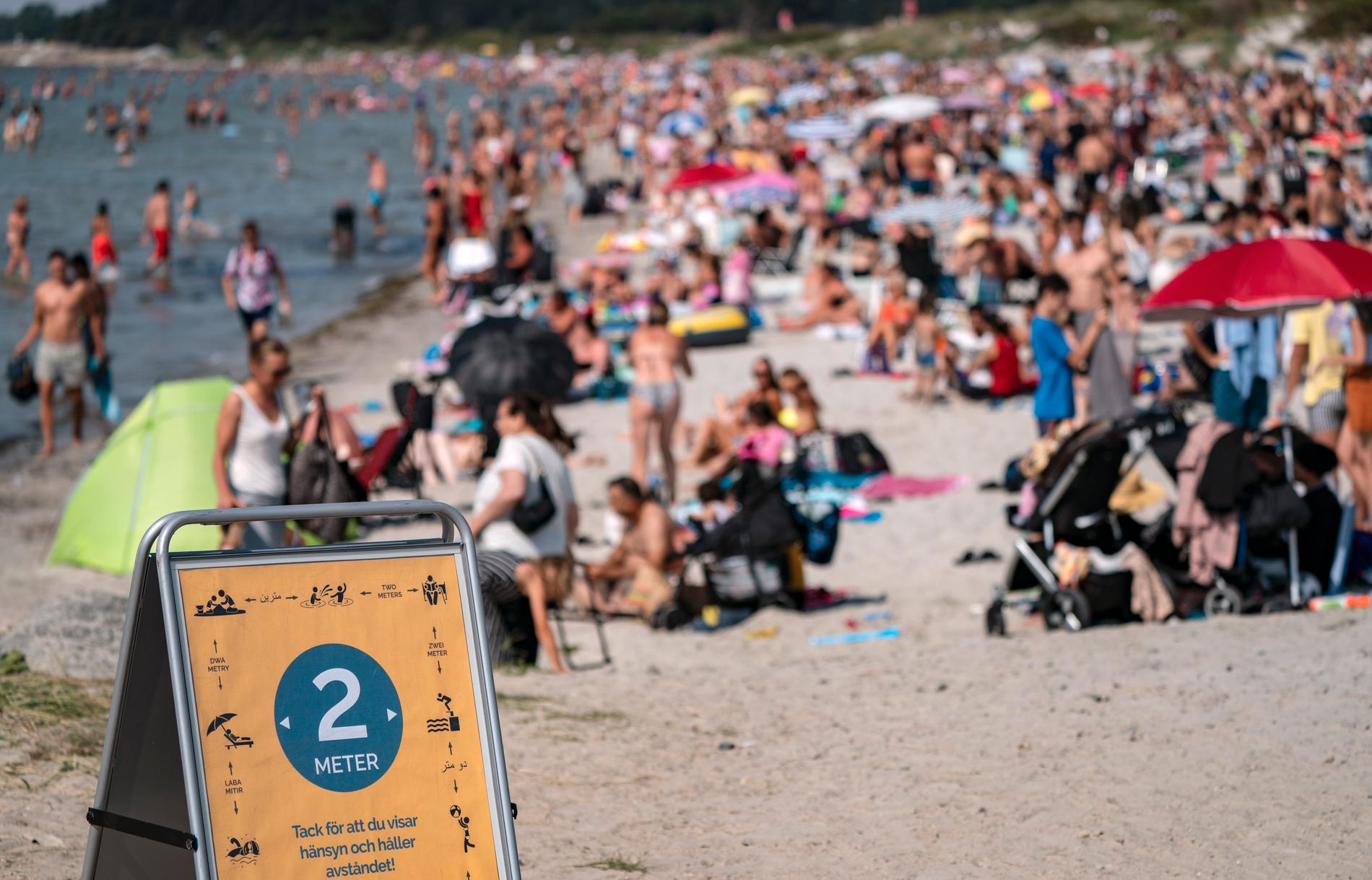 En skylt påminner om att hålla avstånd på stranden i Lomma.