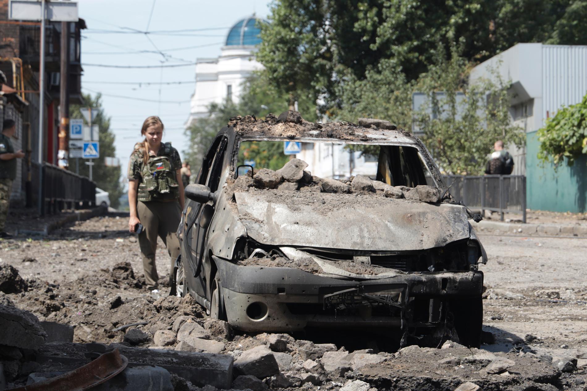 En utredare undersöker en förstörd bil efter en attack i Donetsk vid månadsskiftet.