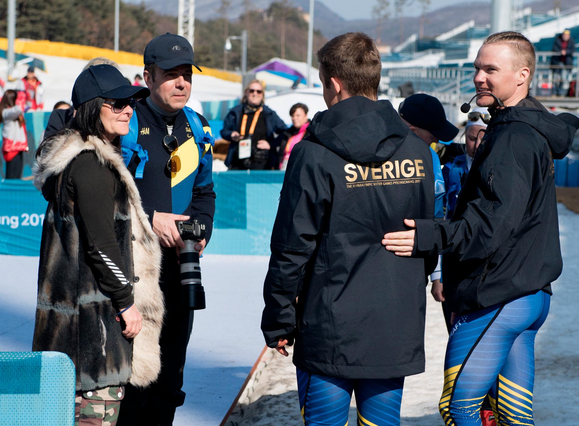Mamma Anette, längst till vänster, och pappa Patrik gratulerar Zebastian Modin till Paralympics-silvret – på avstånd. Till höger guiden Robin Bryntesson.