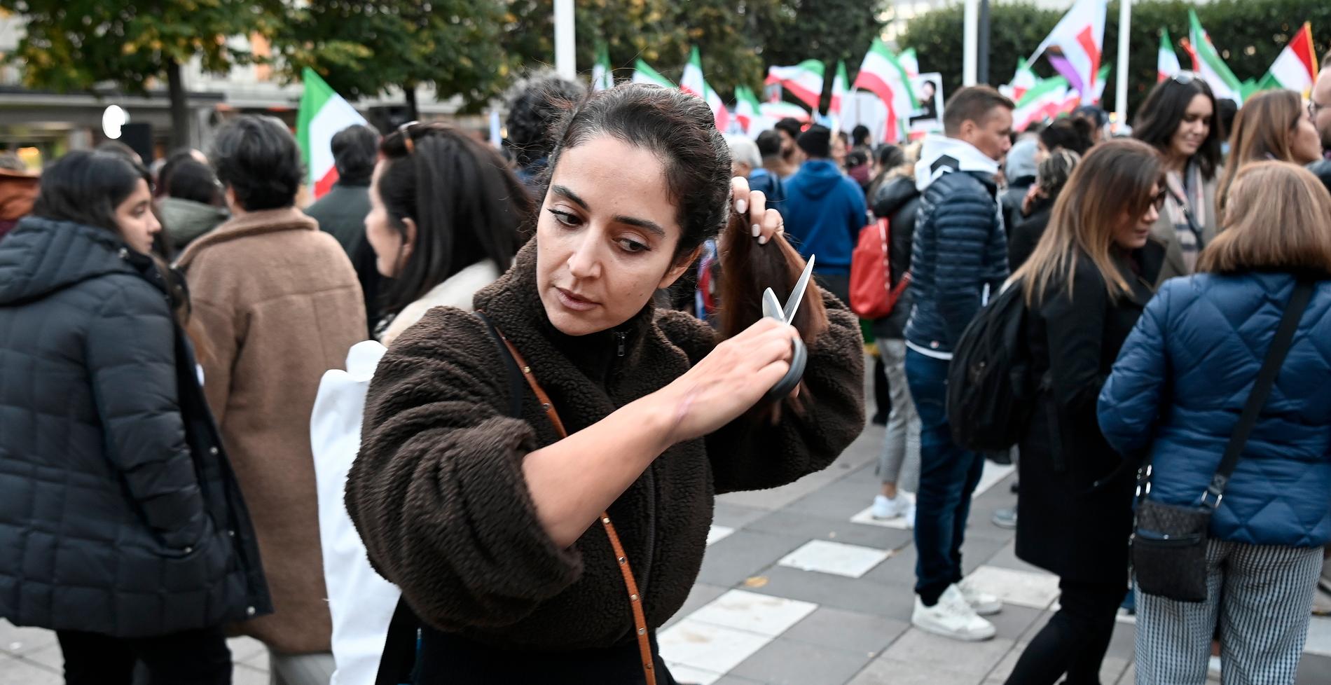 Norrmalmstorg, Stockholm. En kvinna klipper av sig håret i sympati med kvinnorna i Iran. 
