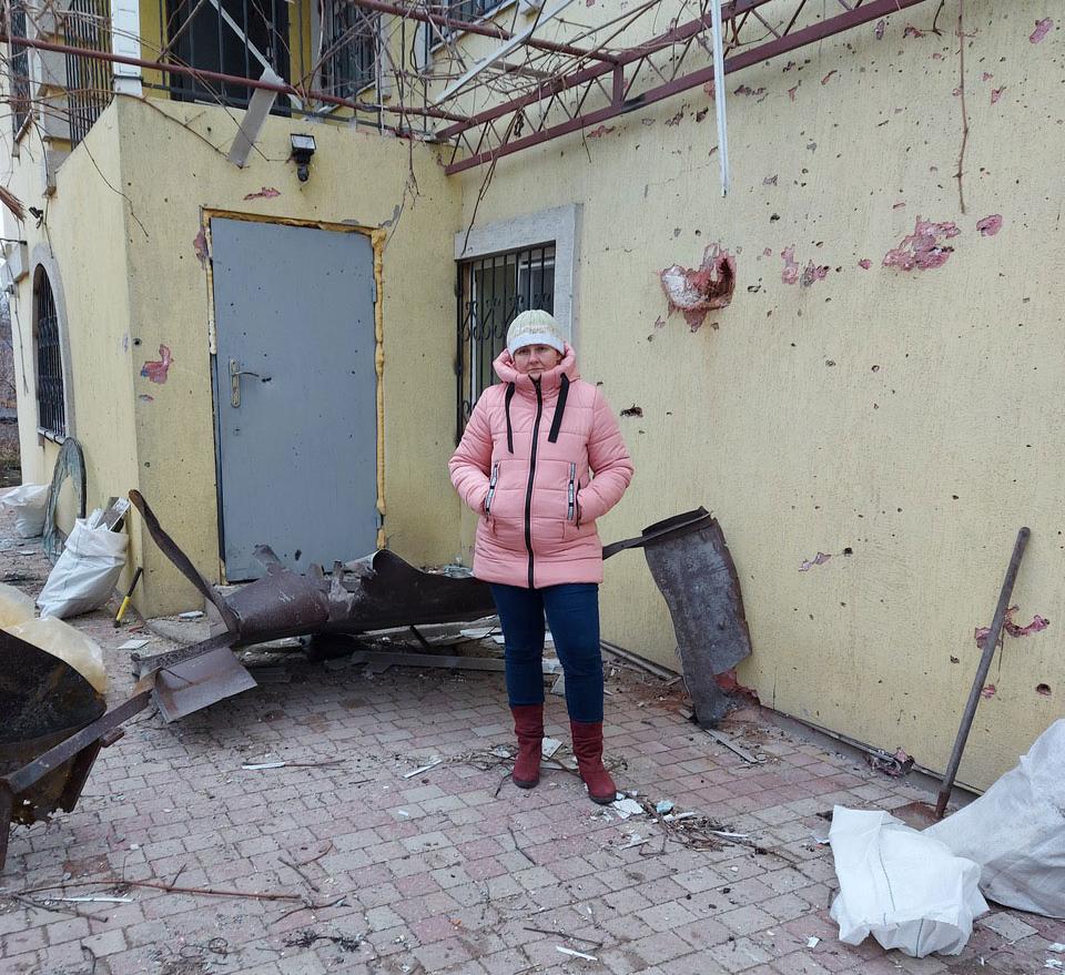 Olga Gritsaj utanför sitt hus som beskjutits av ryska styrkor.
