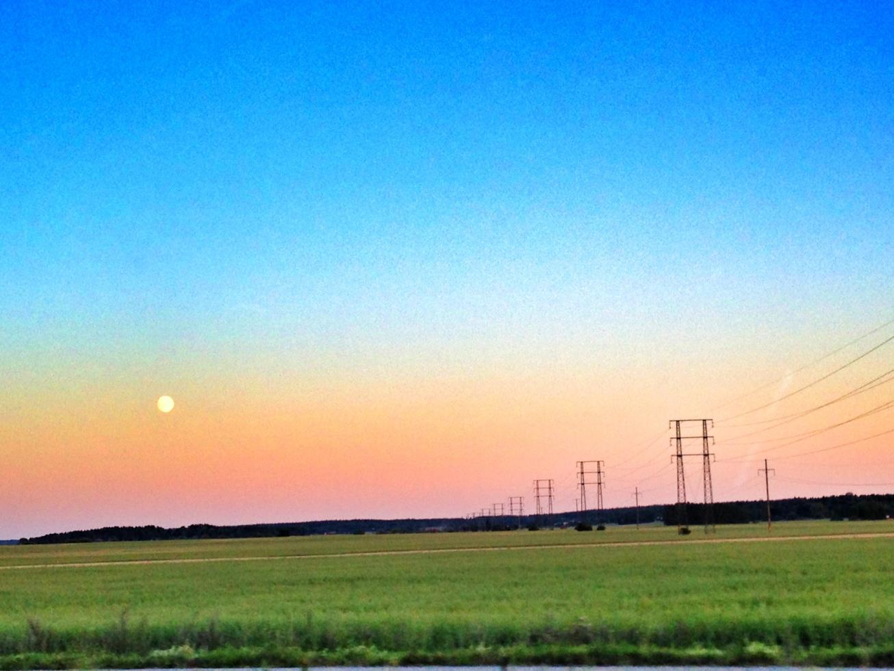 Solnedgång + månen = en fin bild tagen genom bilrutan i full fart.