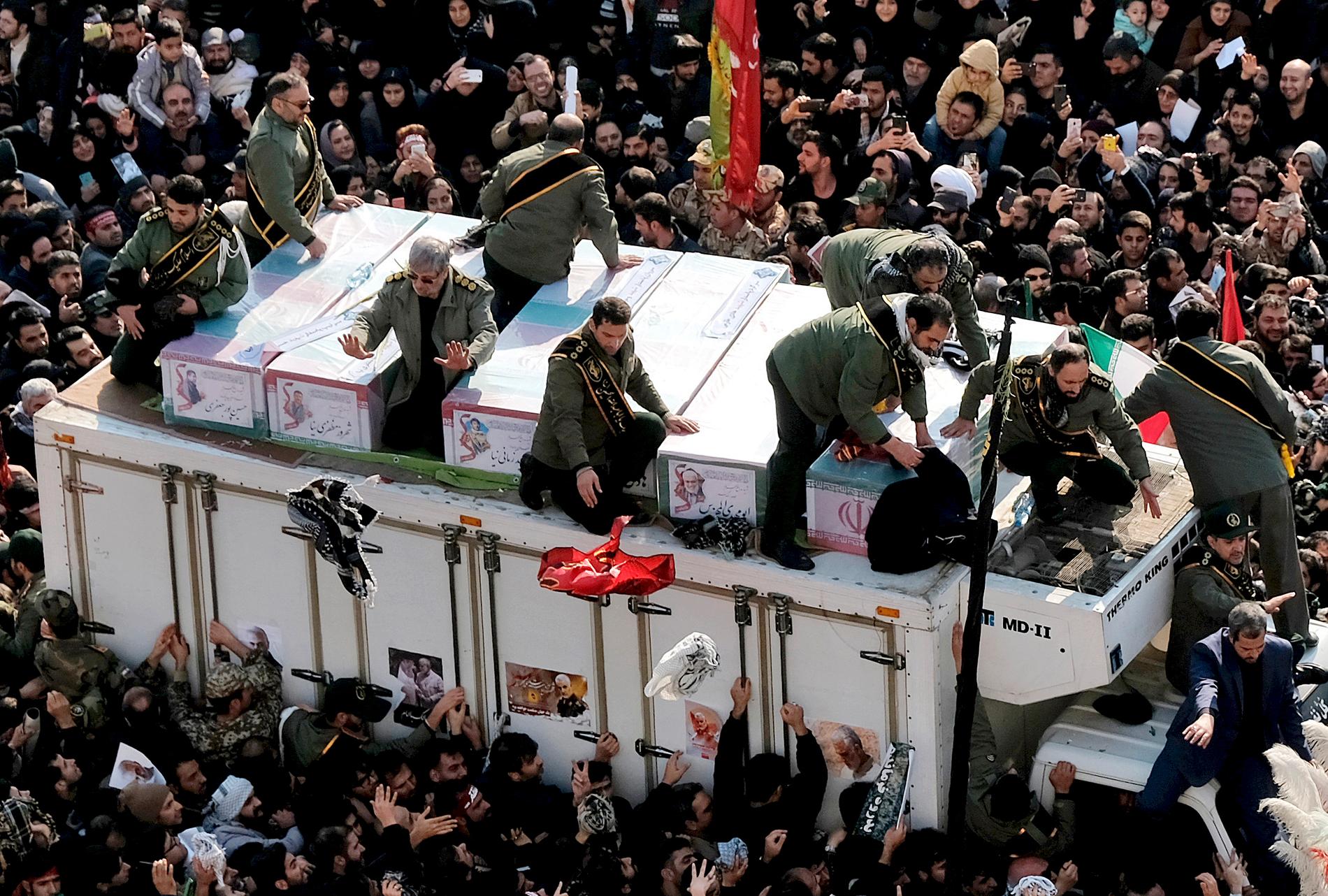 Kistorna med Qassem Soleimani och de andra som dödades i attacken förs fram på en lastbil under ceremonin i Teheran, måndagen 6 januari.