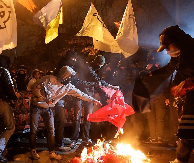 Ukrainska högerextremister bränner kommunistpartiets flaggor i Kiev i oktober.