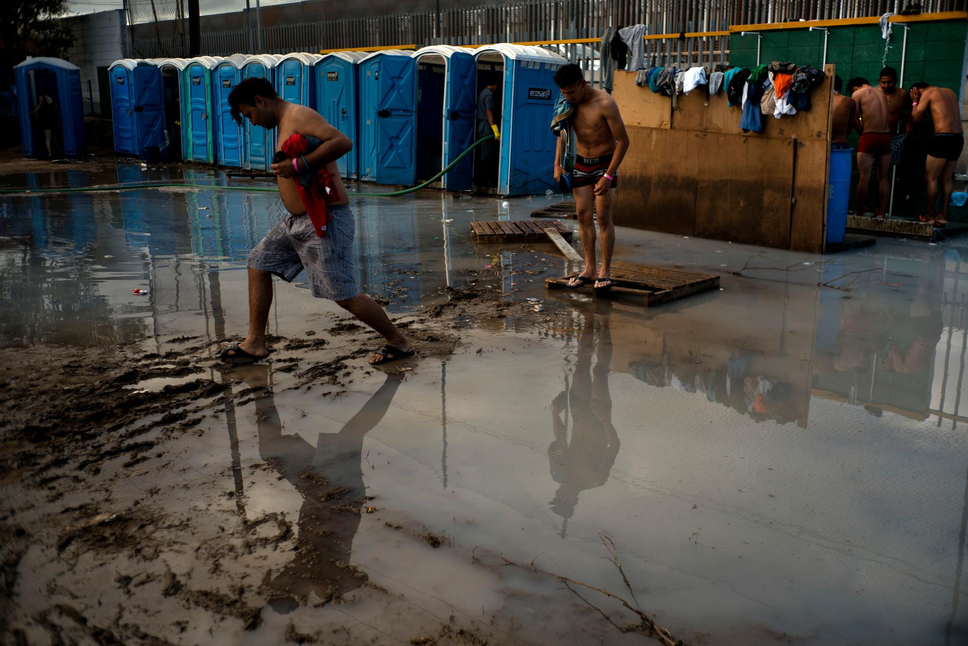 Migranter från Centralamerika vid toaletterna på den idrottsplats i Tijuana i Mexiko där de väntar på att få söka asyl i USA.