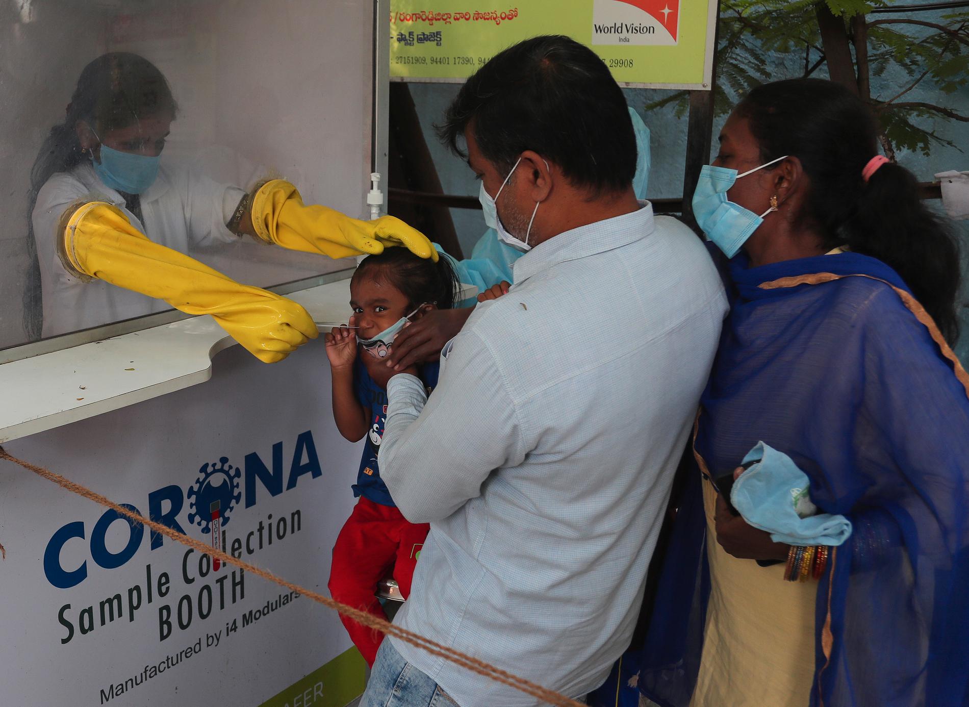 Vårdarbetare testar en familj för coronaviruset i indiska Hyderabad i oktober.