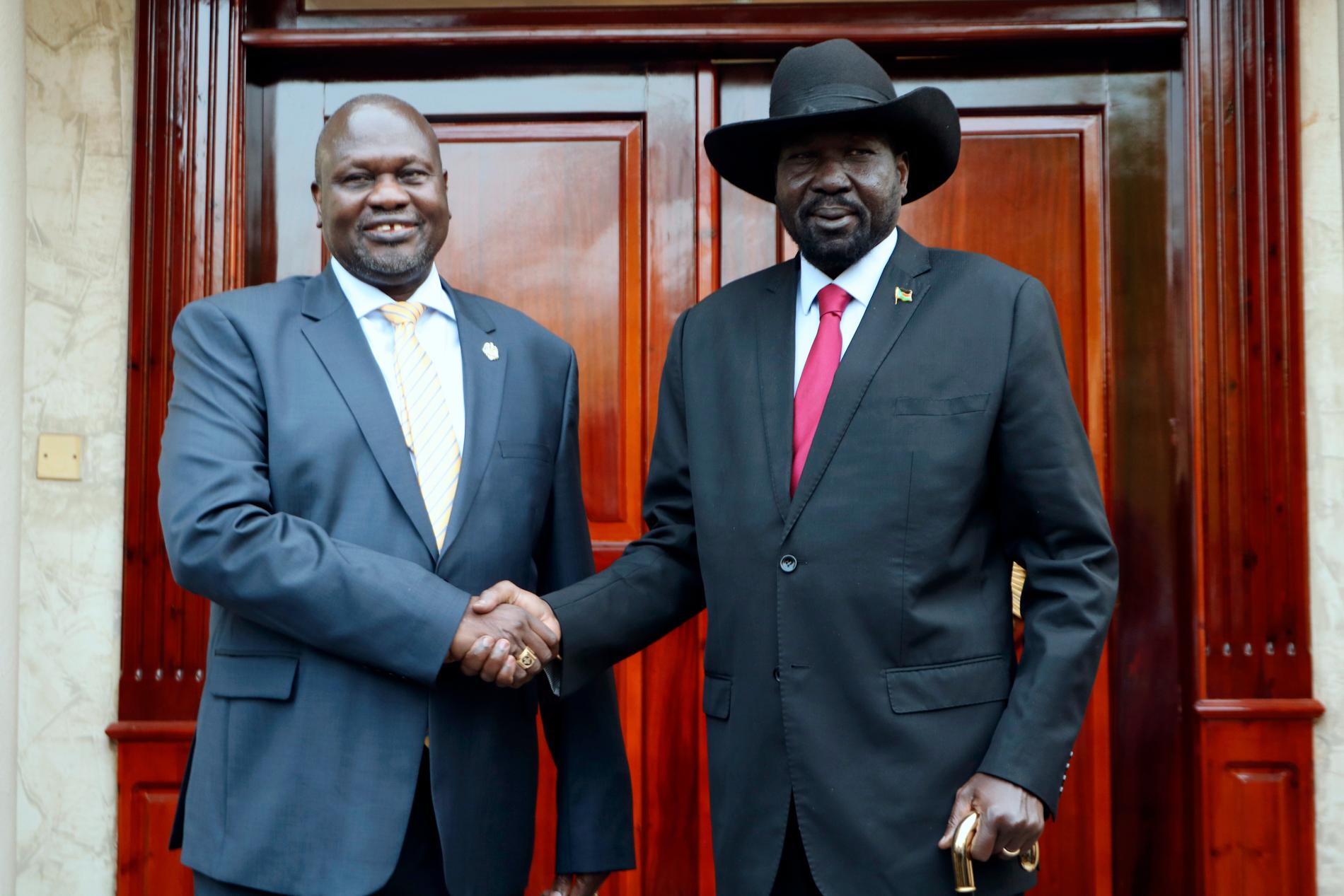 Riek Machar, till vänster, tar Sydsudans president Salva Kiir i hand under deras möte i Juba i måndags.