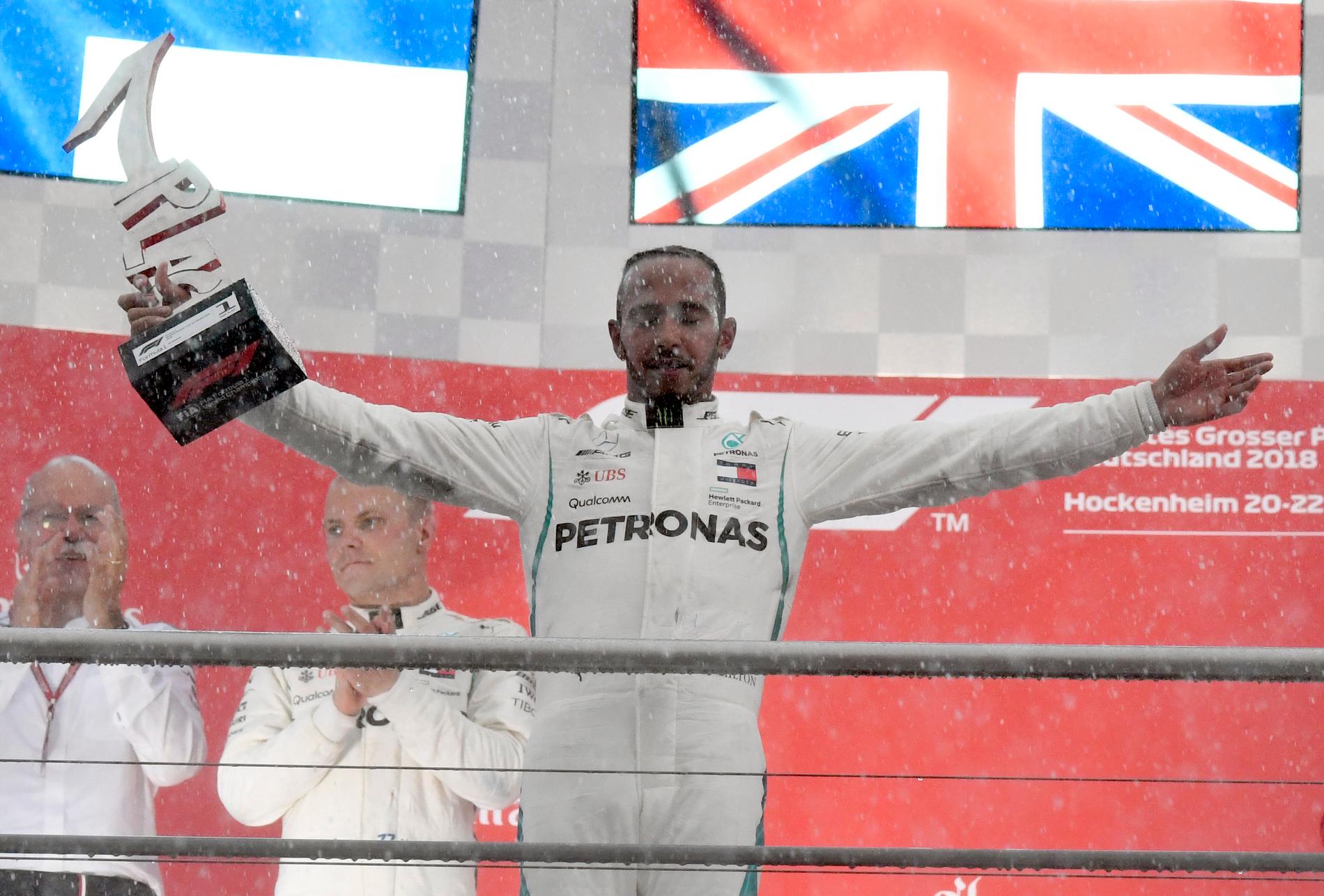 Regnet vräkte ner efter målgången. En blöt men lycklig Lewis Hamilton kunde fira på prispallen.