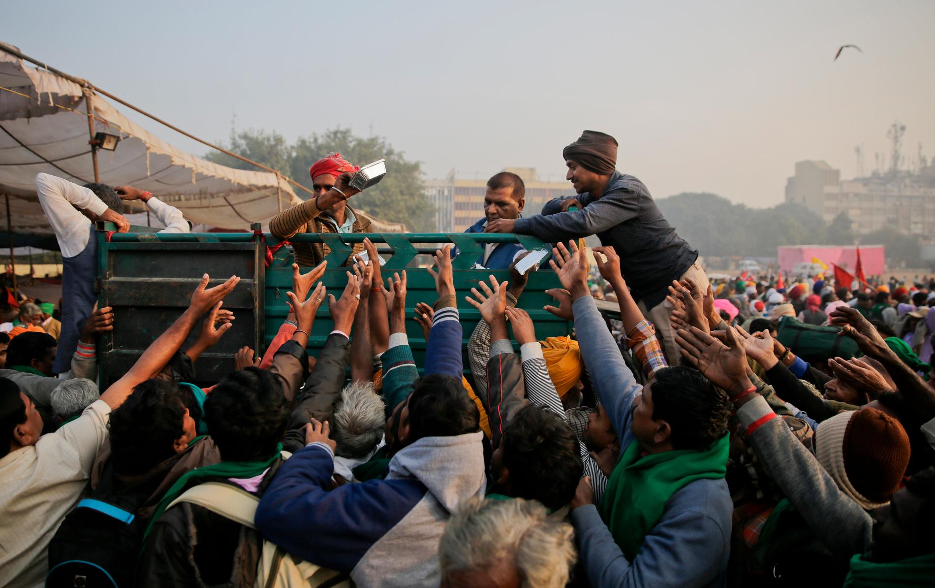 Frivilliga delar ut frukost till några av de tiotusentals lantbrukare som väntas demonstrera i Dehli.