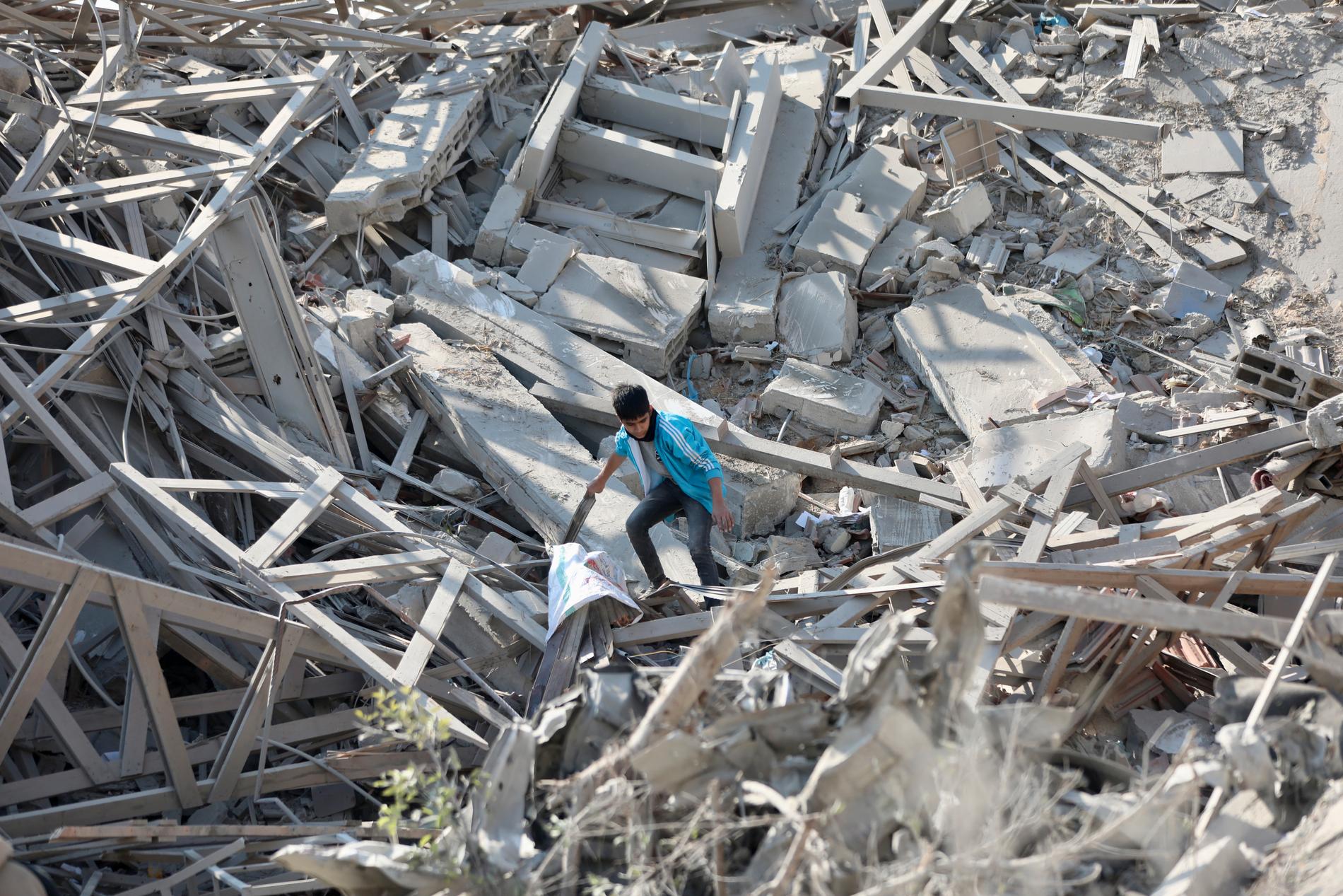 En pojke går genom bråte som varit byggnader i Gaza City i februari.