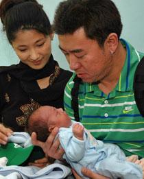 Thomas och Karen Kim från Kalifornien håller sin son som fötts av en kvinna från Calcutta.
