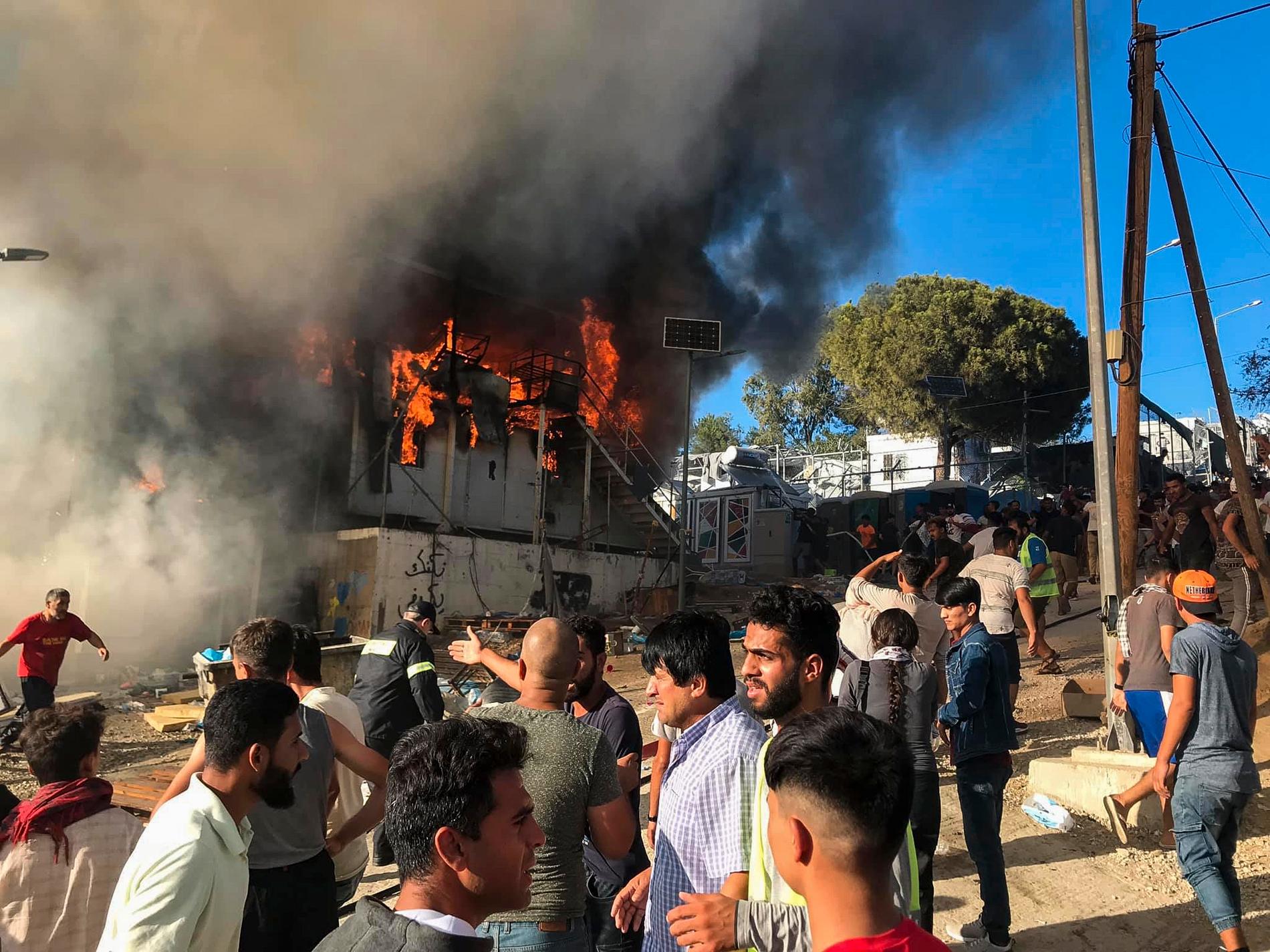 En brand i en container utlöste protester i går i ett överfyllt migrantläger på den grekiska ön Lesbos. Myndigheter säger att asylsökande ska förflyttas från anläggningen med minst 12 000 boende till det grekiska fastlandet.