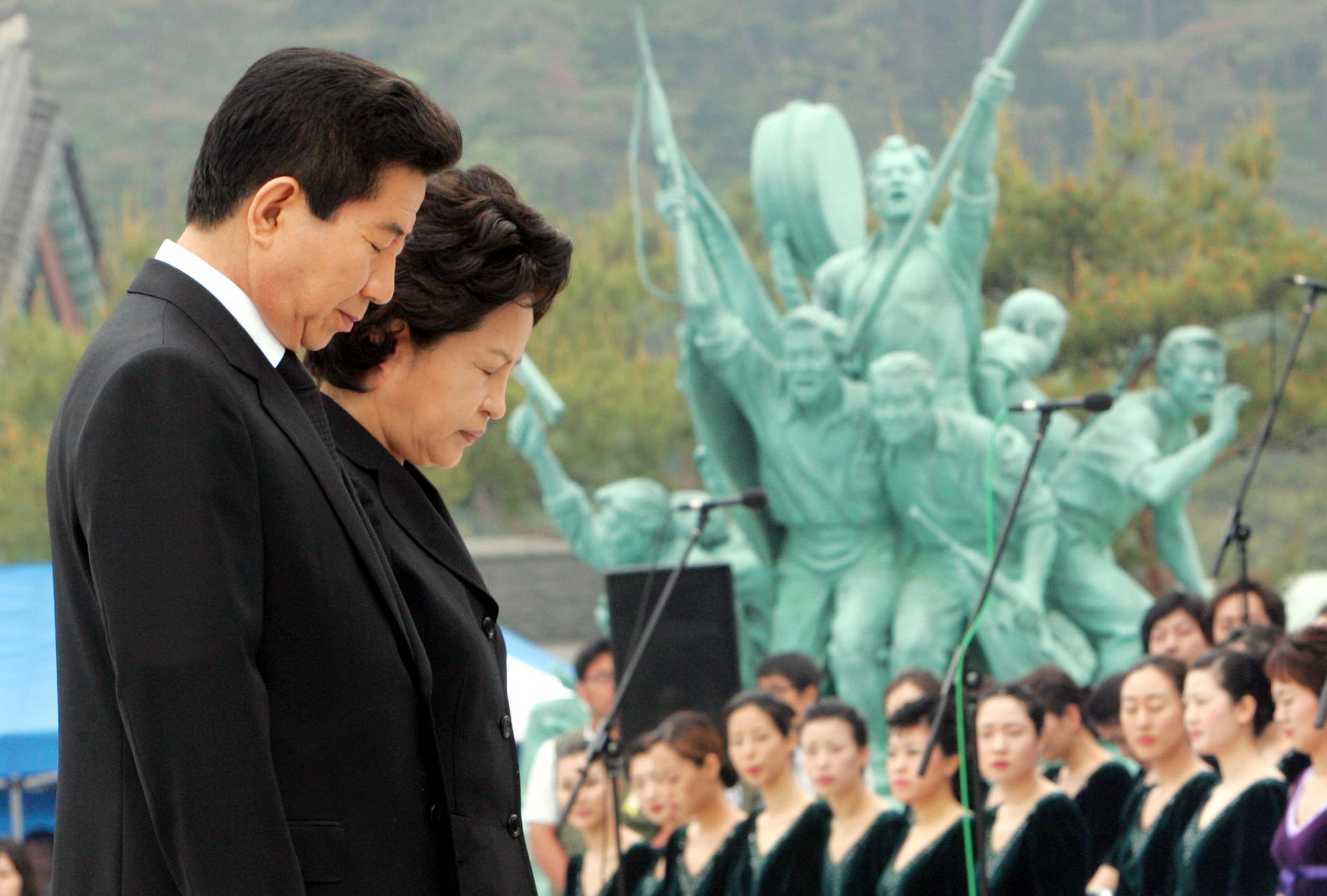 2006 hedrade dåvarande president Roh Moo-hyun och hans fru Kwon Yang-sook offen för upproret i Gwangju 1980 framför ett minnesmonument.