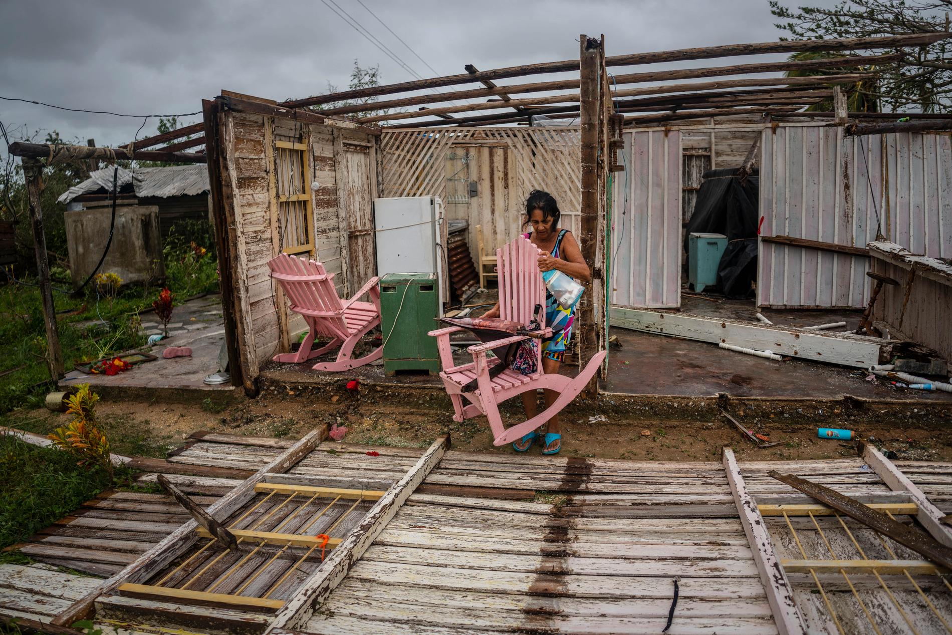 En kvinna försöker rädda ägodelar från sitt orkanrammade hus i Pinar del Río på västra Kuba.