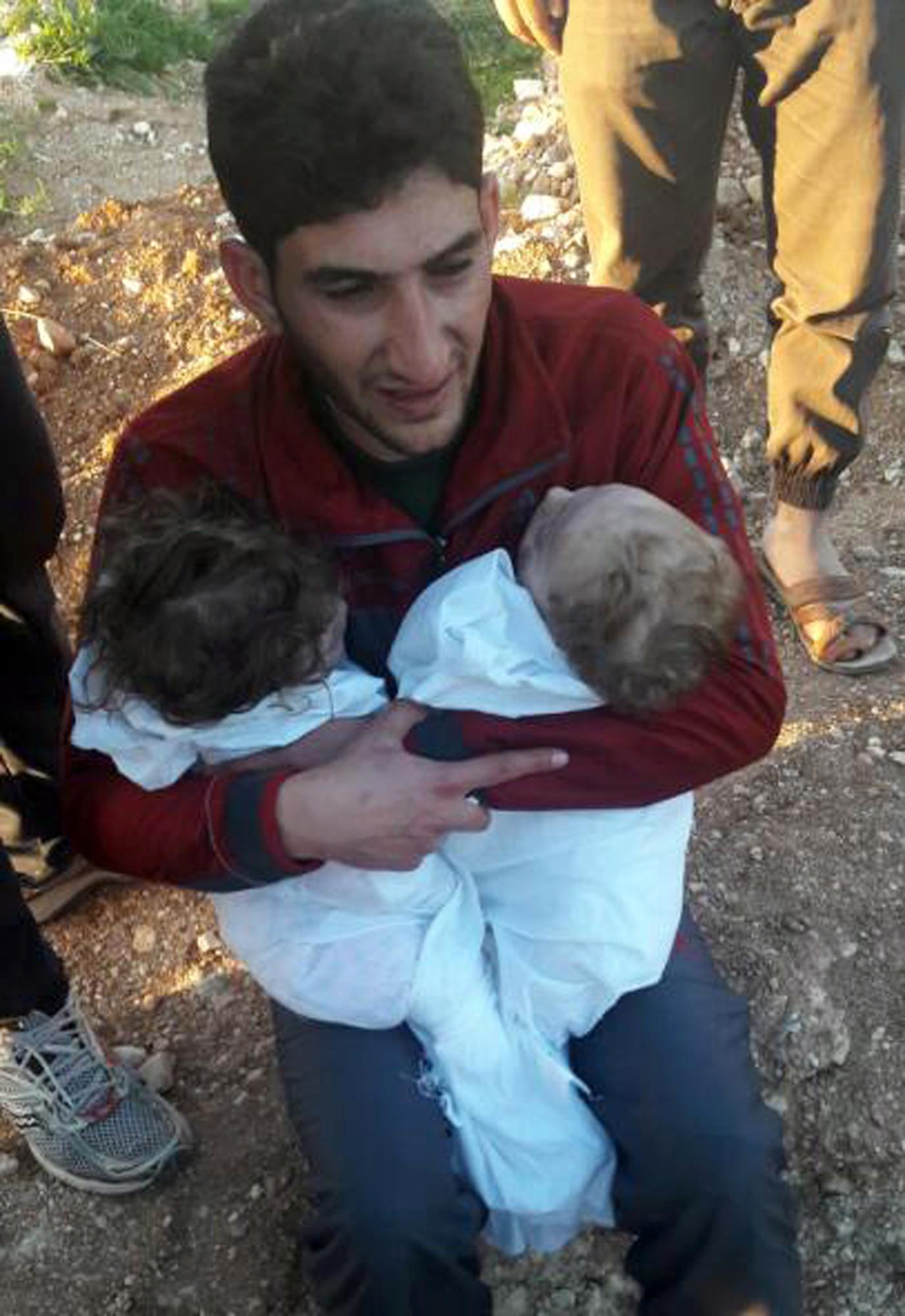 Abdel Hameed Alyousef håller om sina barn som inte överlevde gasattacken.