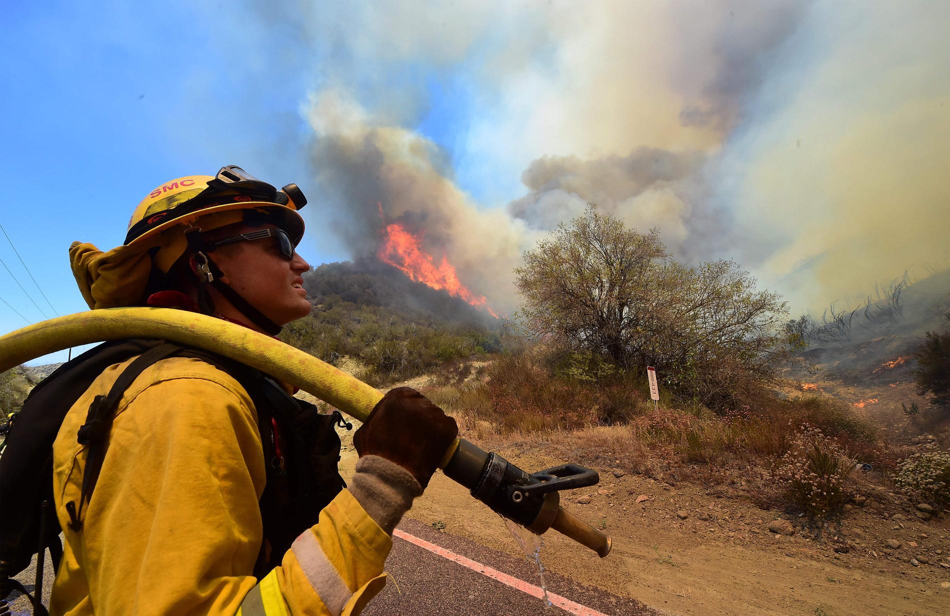 En brandman undersöker platsen nära en eldsvåda på en kulle vid Placerita Canyon Road.