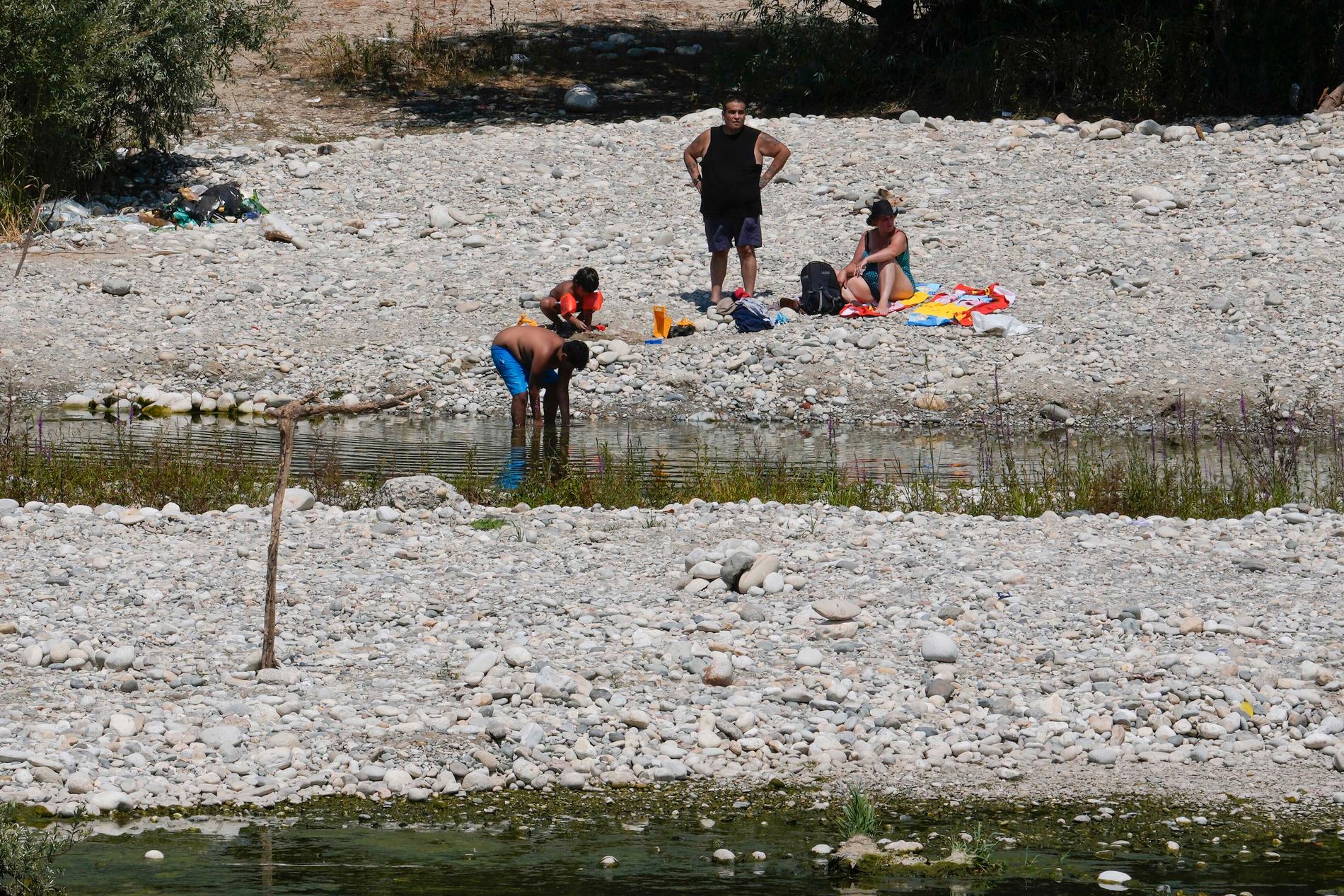 Italien har drabbats av torka. Här söker invånare nära Milan svalka i en kanal. 