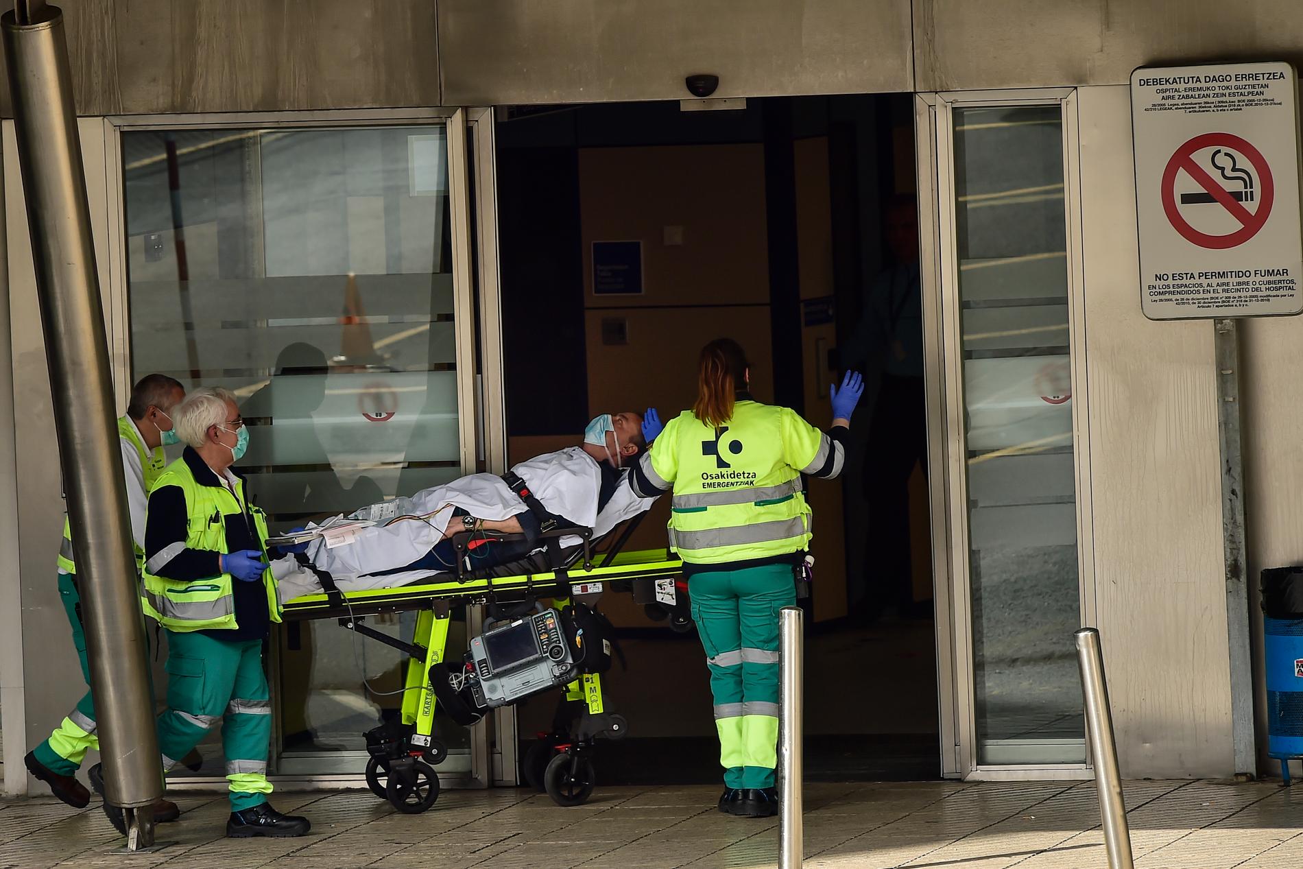 Ambulanspersonal bär masker när en patient anländer till sjukhuset. 