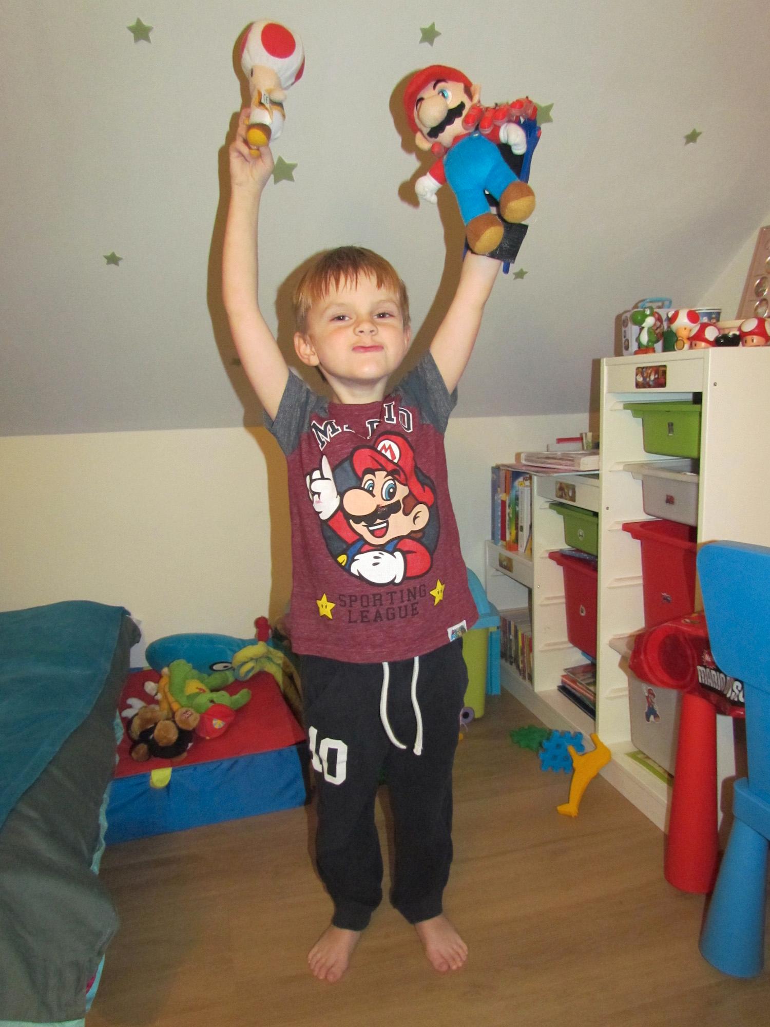 Superglade Antoni med sin superhjälte Antoni, 6, i Polen med sin Super Mario-gubbe. Tack vare den nya 3D-protesen kan Antoni nu greppa en leksak i varje hand.