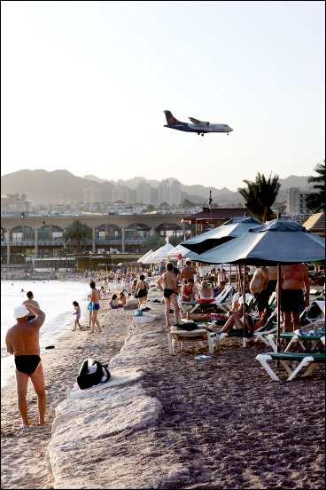 På sin väg in för landning på flygplatsen mitt i Eilat stad nuddar charterplanen nästan den stora shoppinggallerians tak vid Neptune Beach.